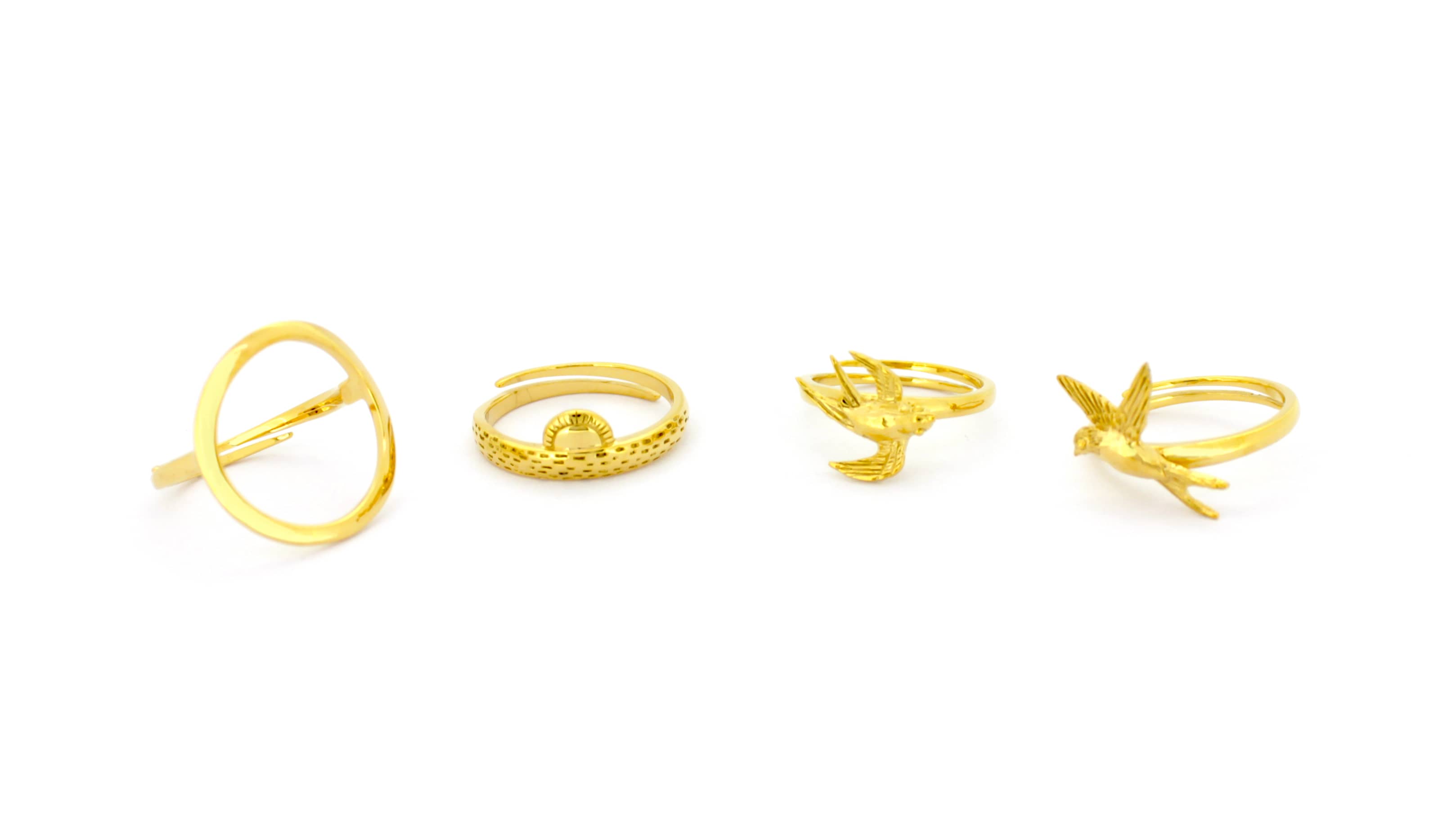 A stunning collection of gold rings featuring unique designs, including two Swallow Rings, a Sun Ring, and a Round Ring.
