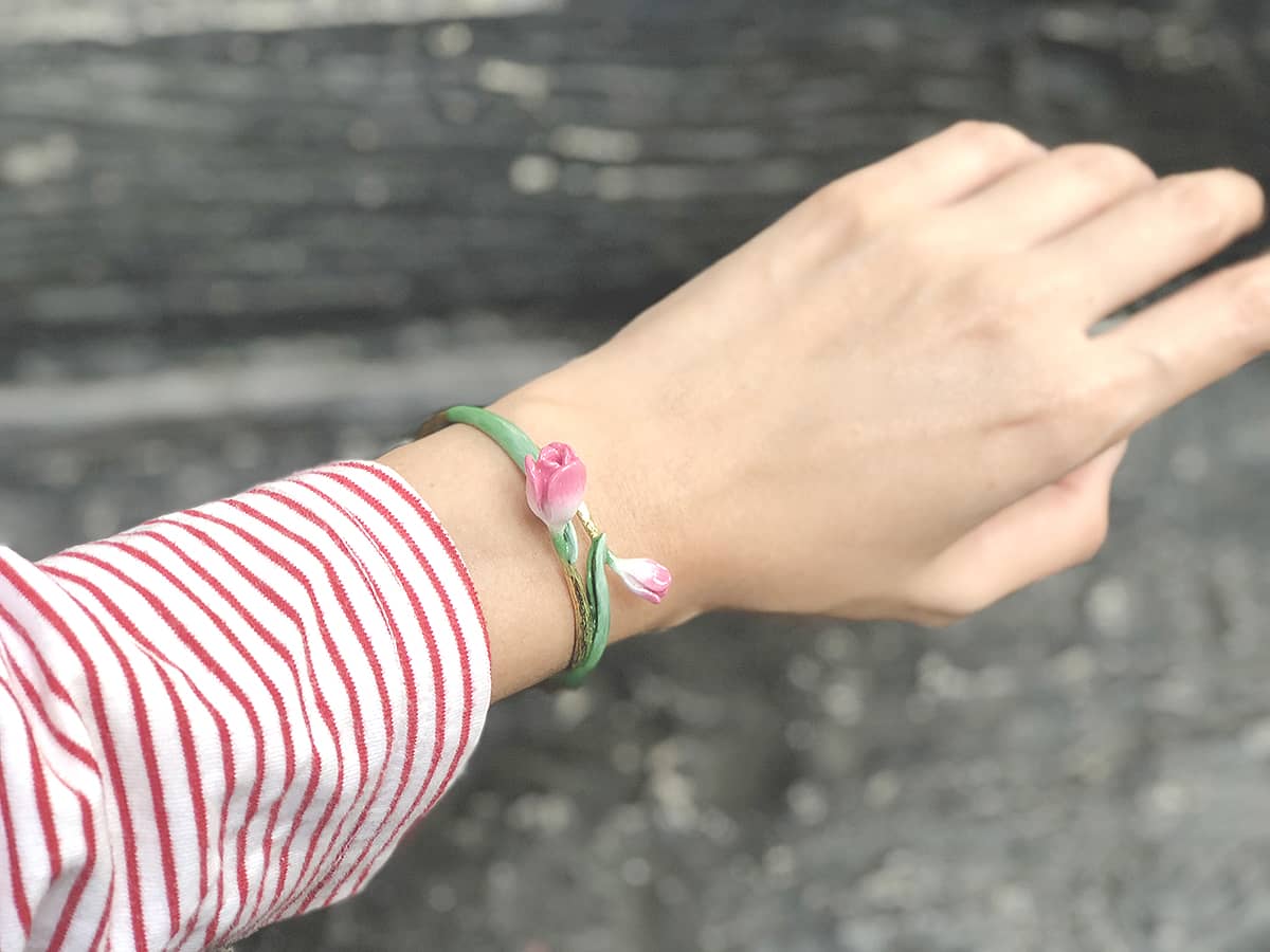 Close-up of a hand adorned with a tulip bangle