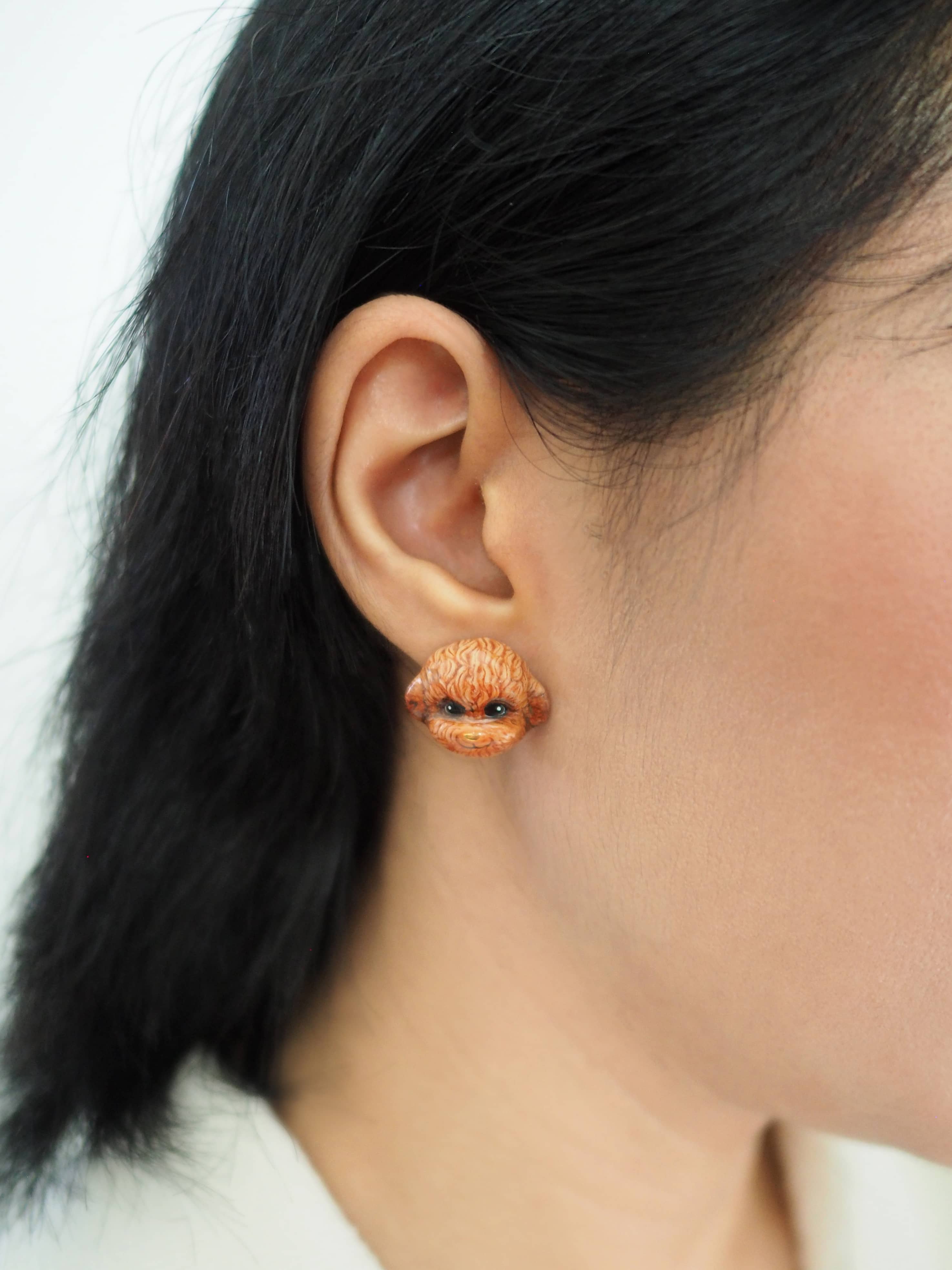 Cute hand-painted poodle earrings worn by a model.