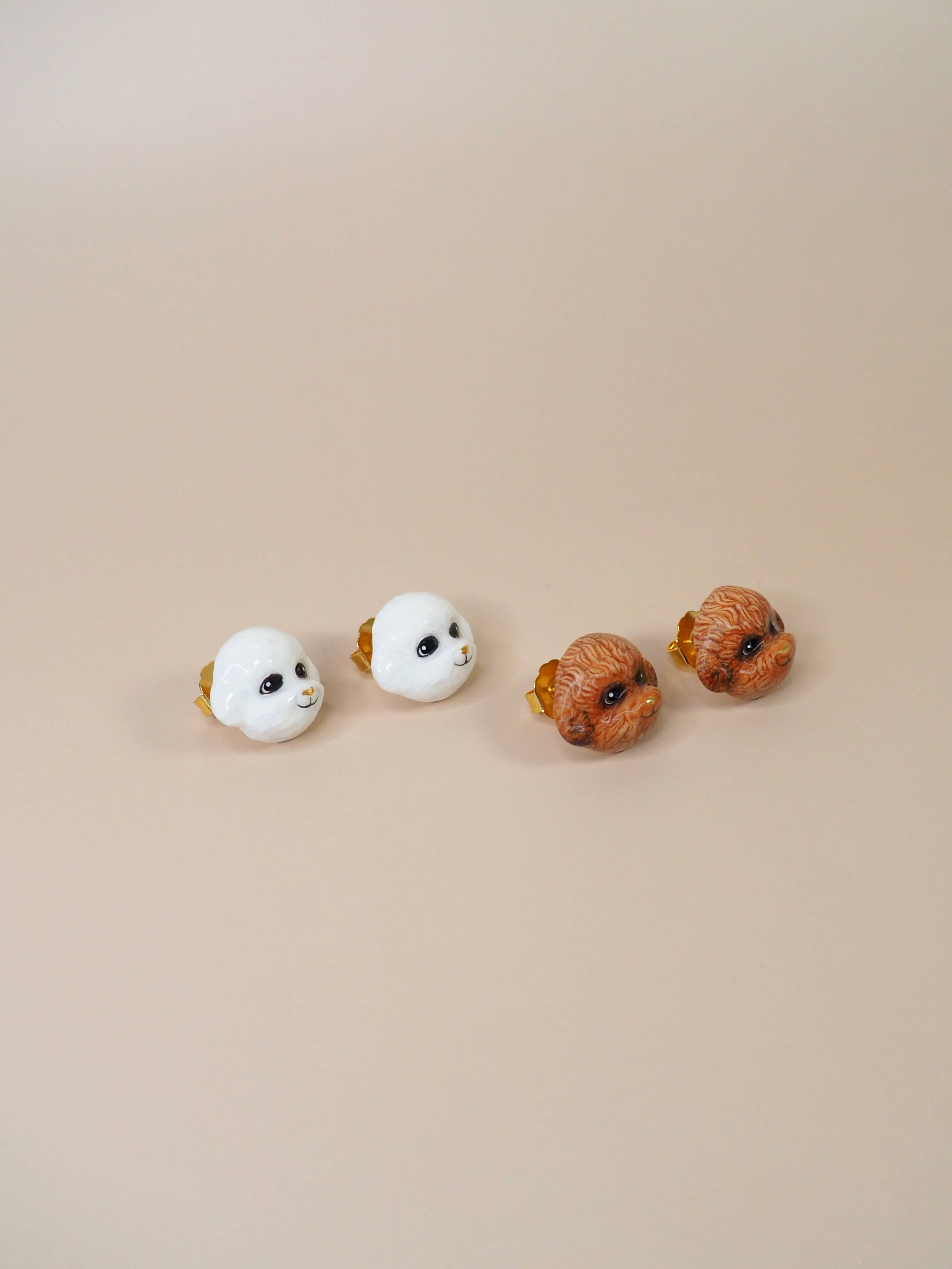 A set of charming poodle earrings showcasing a white and brown poodle.