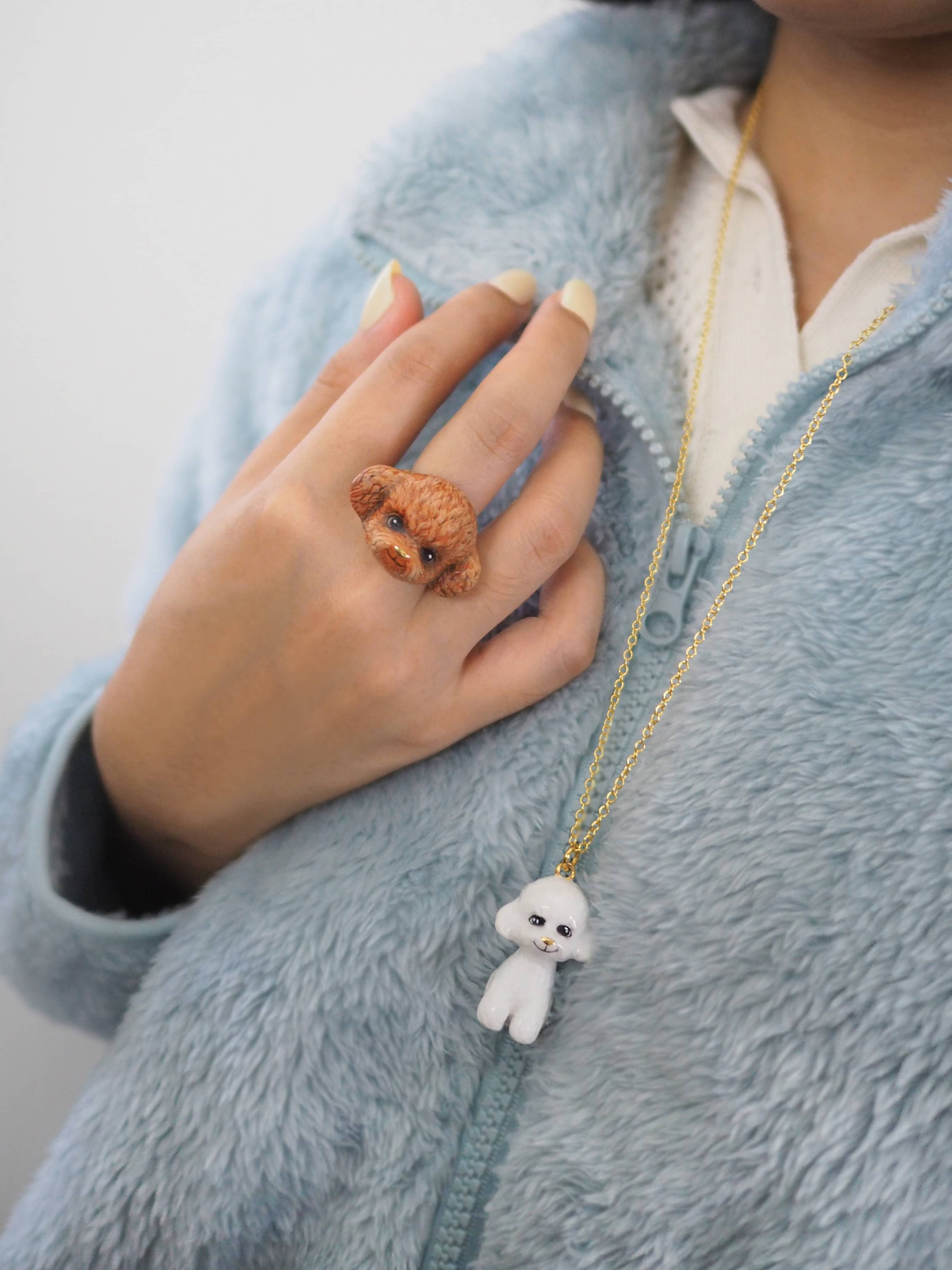 Charming poodle jewelry set featuring a necklace and ring worn on a model.
