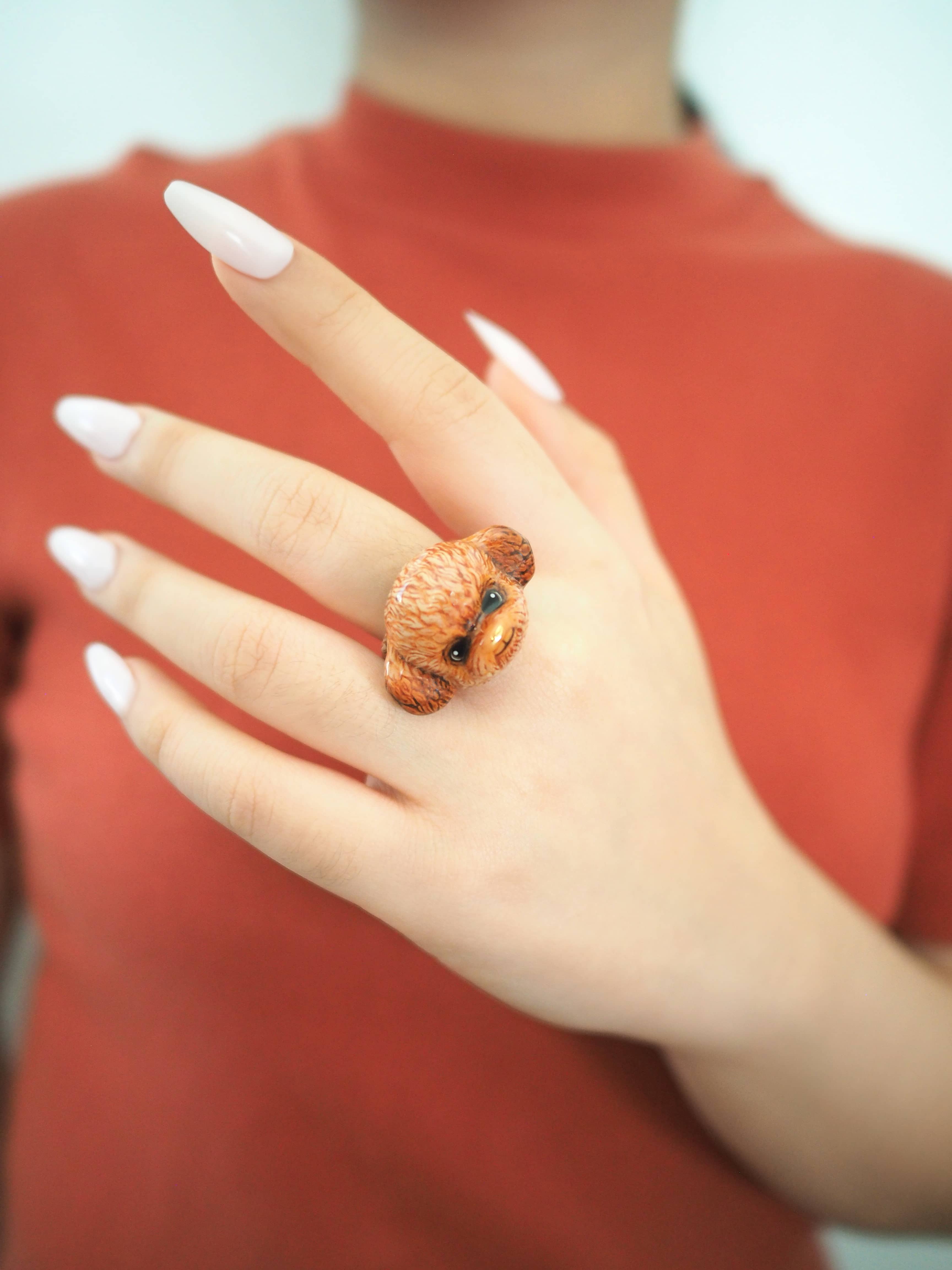 Close-up of a poodle ring on a woman's hand, highlighting a playful and trendy jewelry choice.