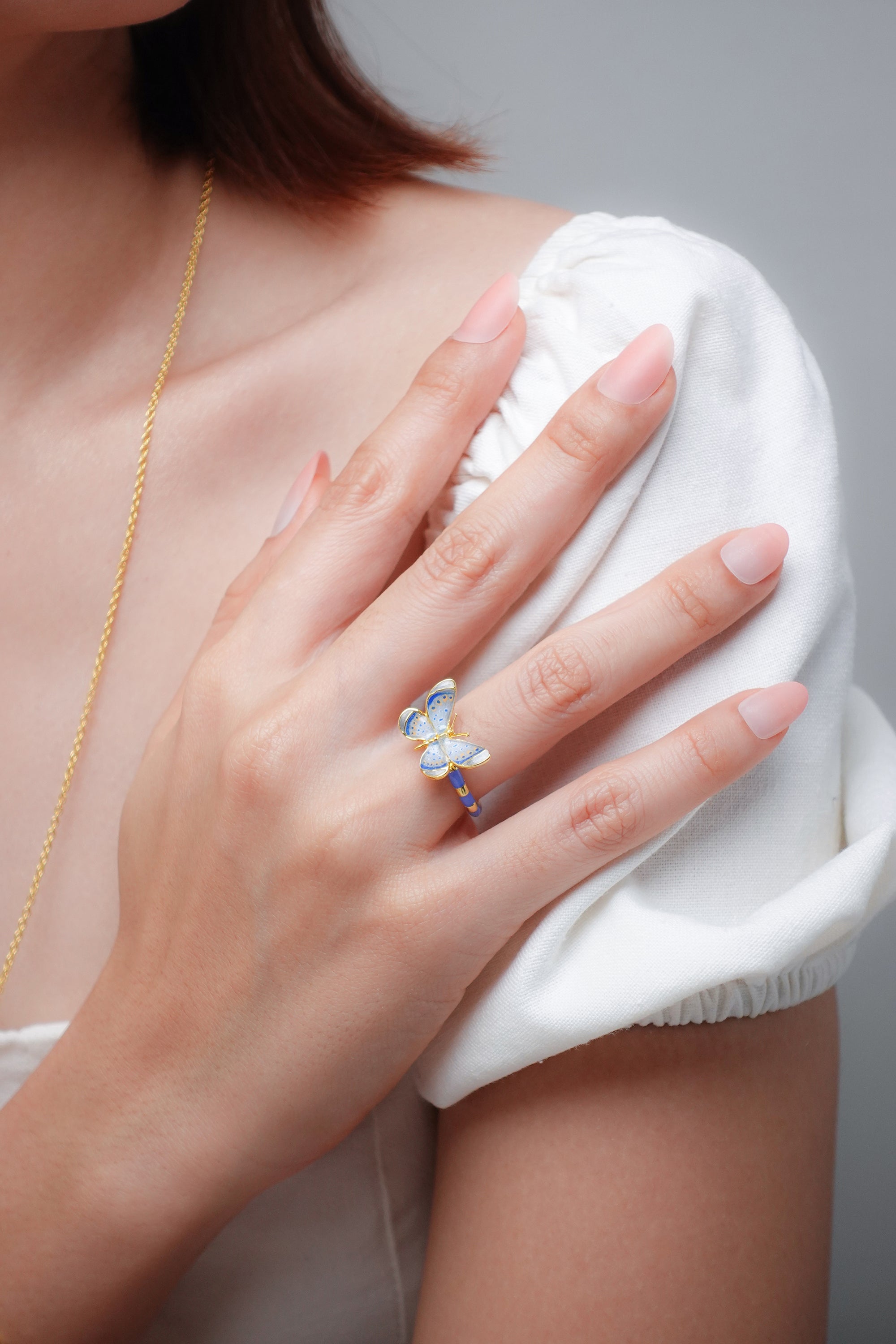 Close-up of a woman's hand wearing a beautiful butterfly ring.