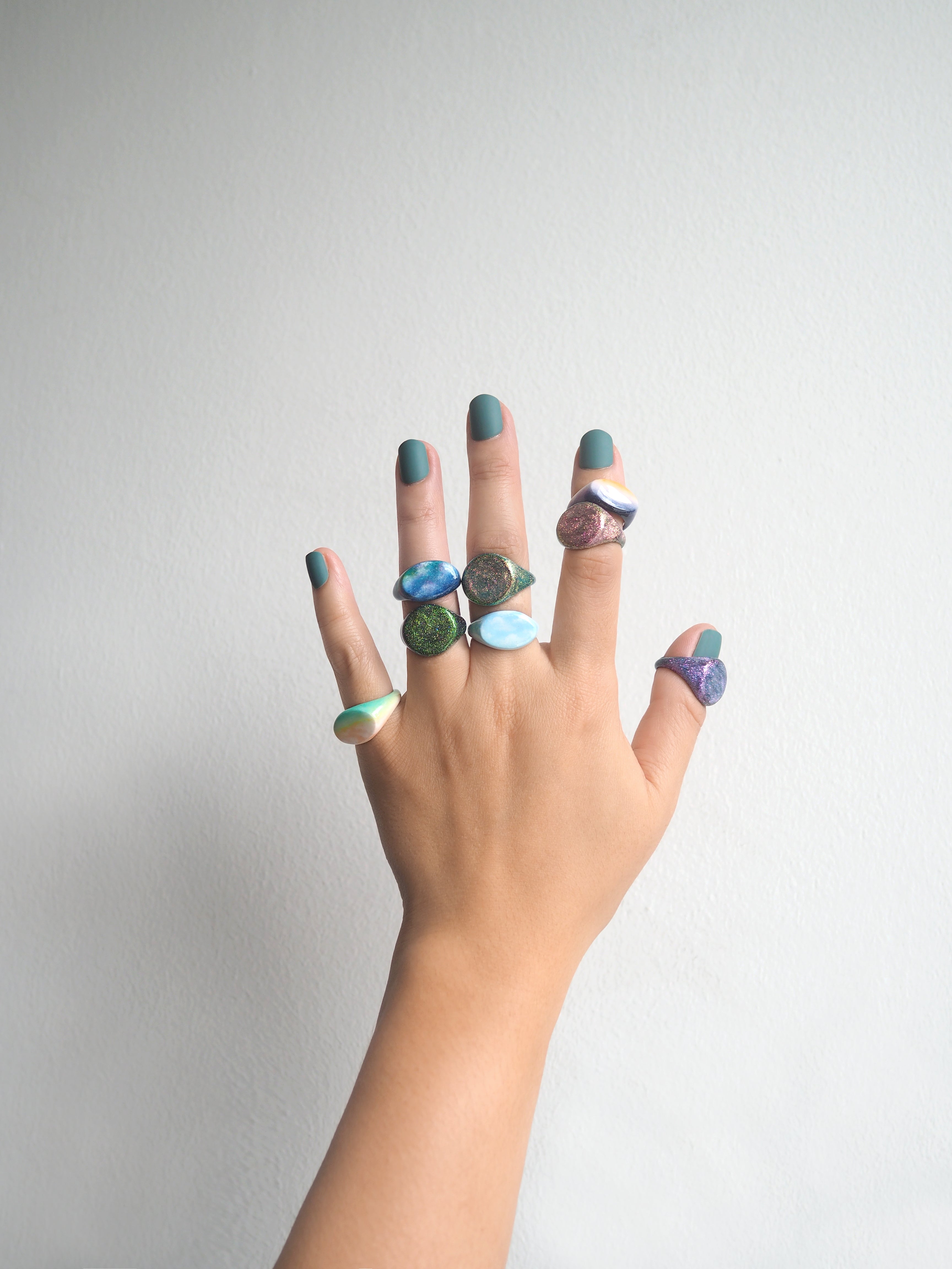 Collection of hand-painted ring featuring a sky design on a hand.