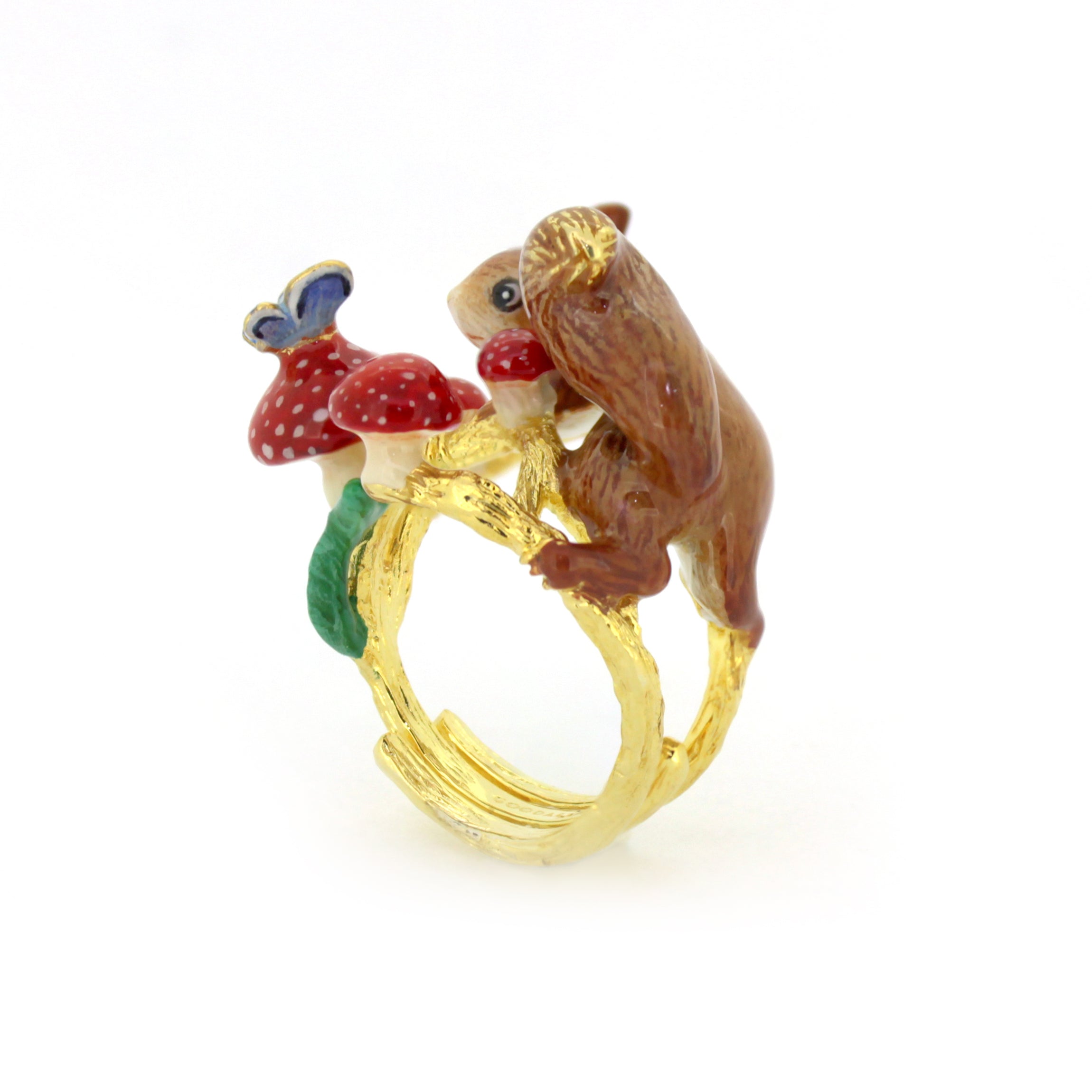 A whimsical ring designed with a detailed squirrel perched near red mushrooms and a blue butterfly