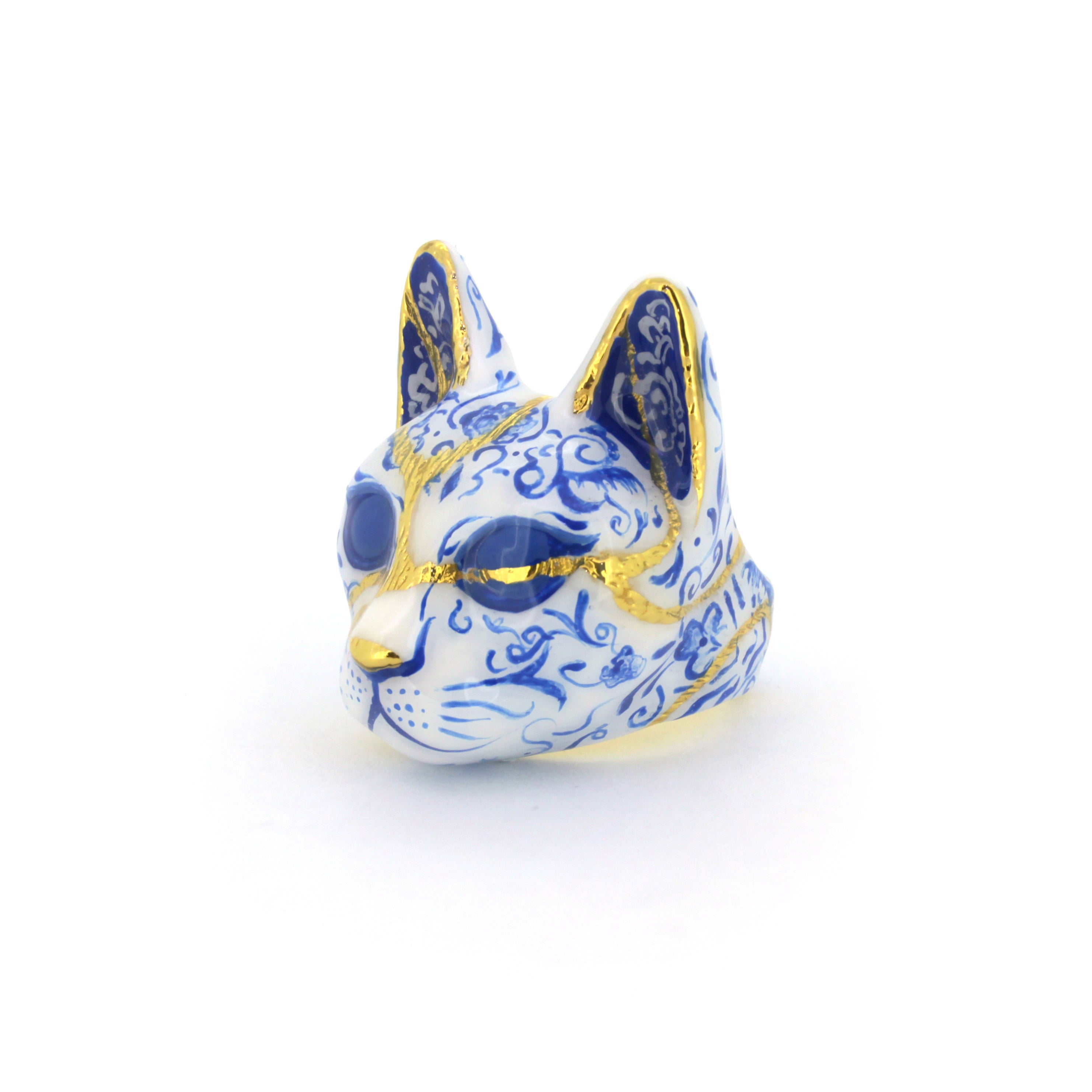 Handmade cat's face ring featuring detailed porcelain patterns, painted in blue and white pattern with gold accents, perfect for art collectors.