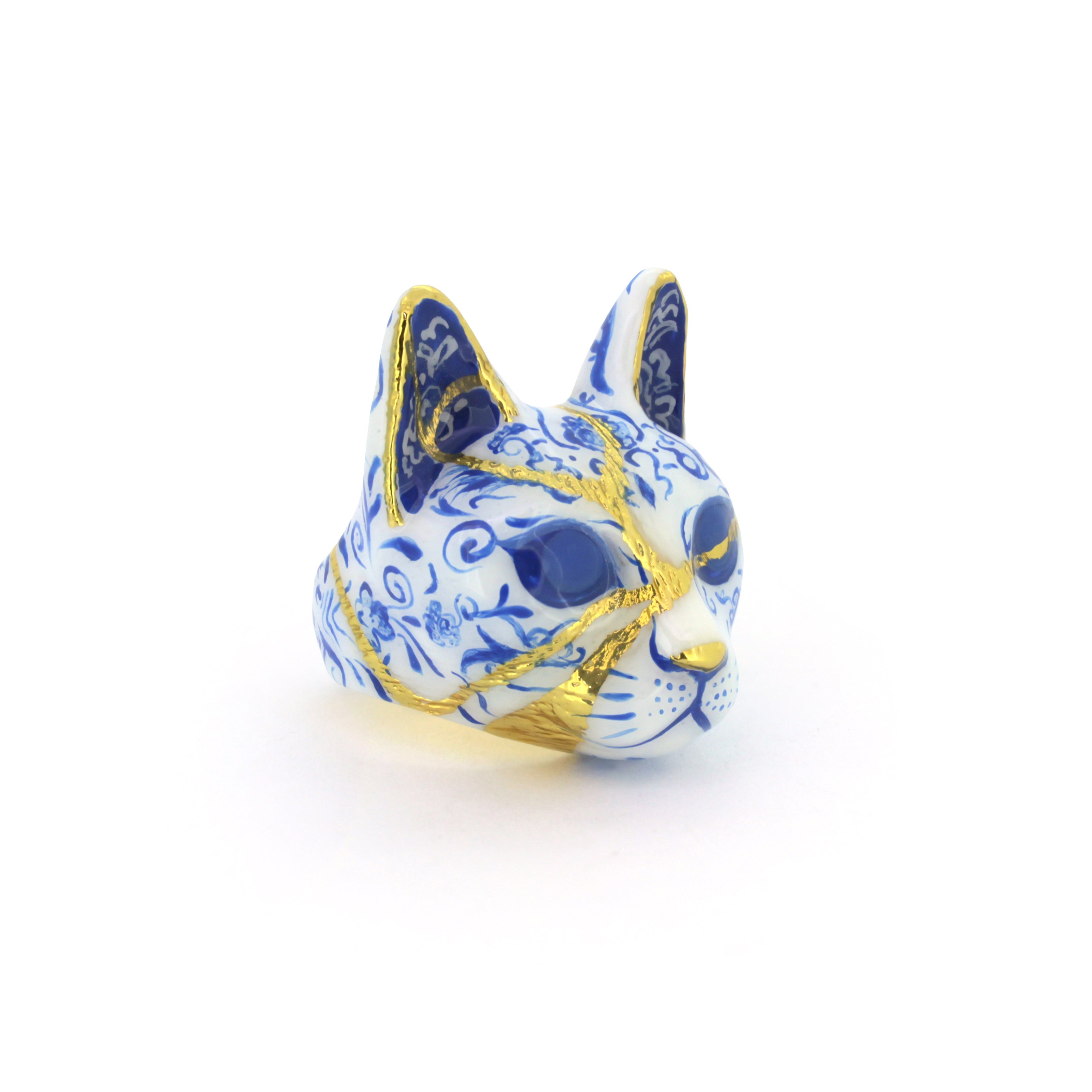 Artisan cat's face ring featuring detailed porcelain patterns, painted in blue and white pattern with gold accents, perfect for art collectors.