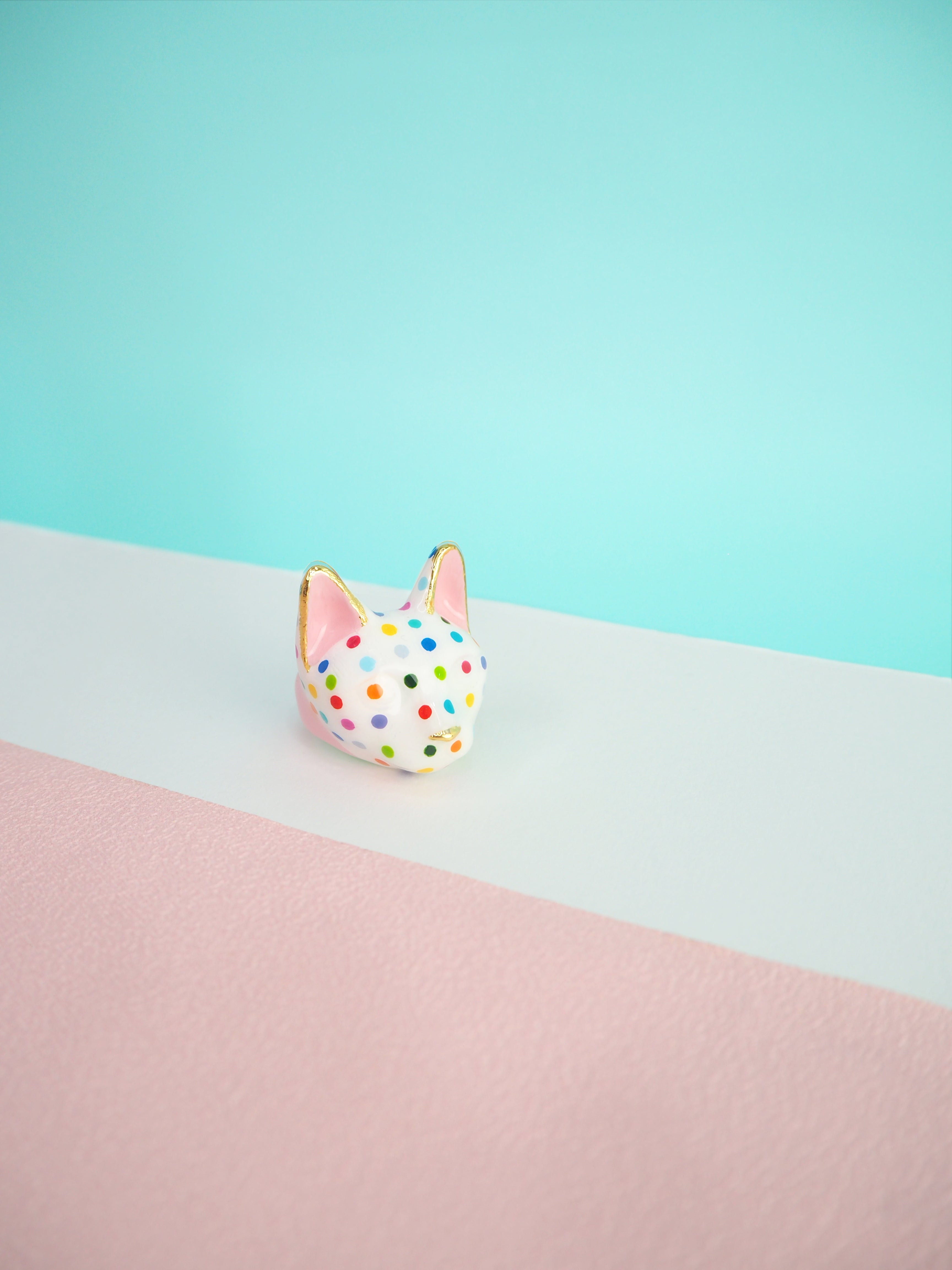 A stylish cat ring with polka dots on a pastel background.