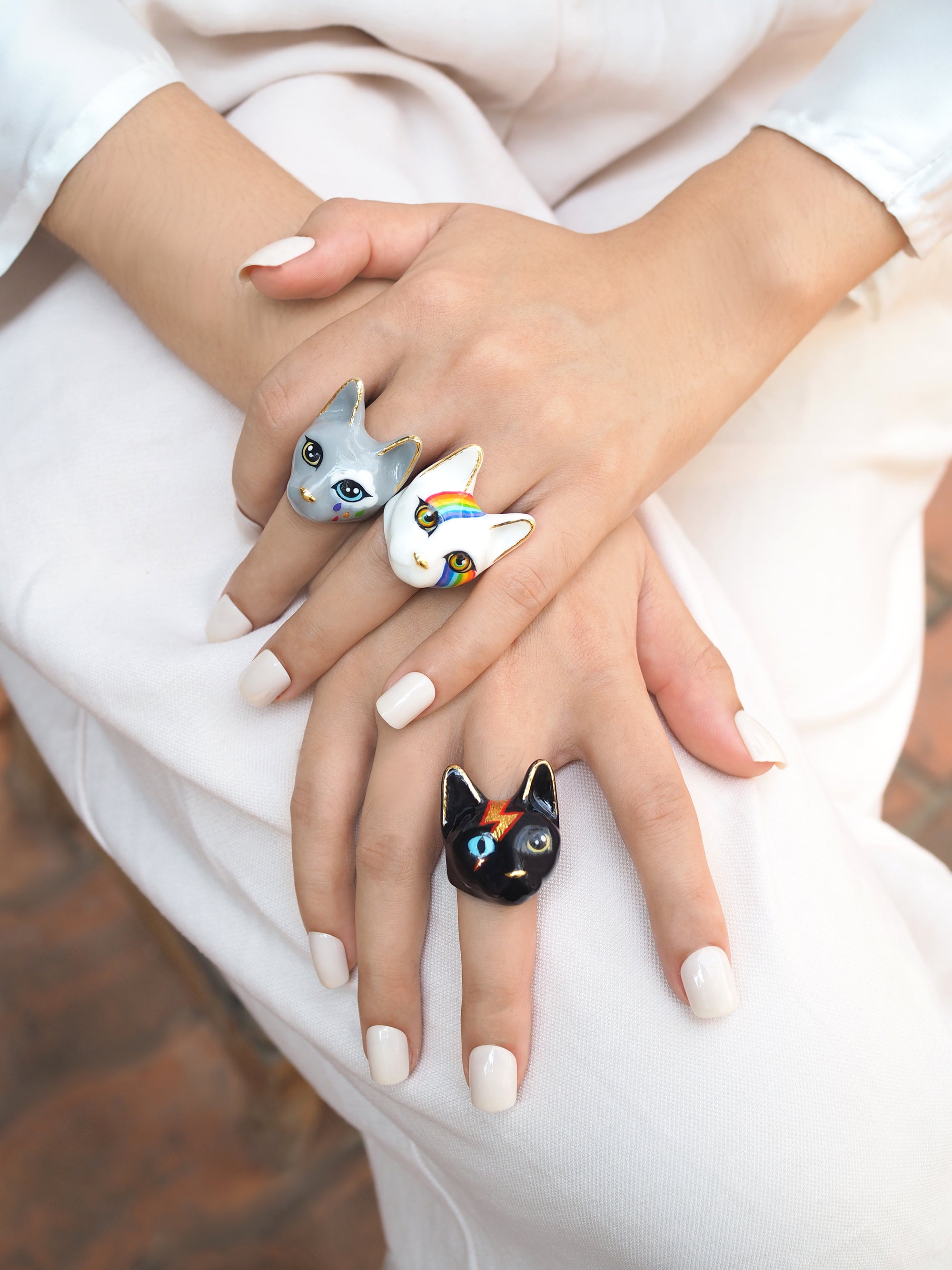 Collection of unique cat rings showcasing designs on fingers, perfect for cat lovers.