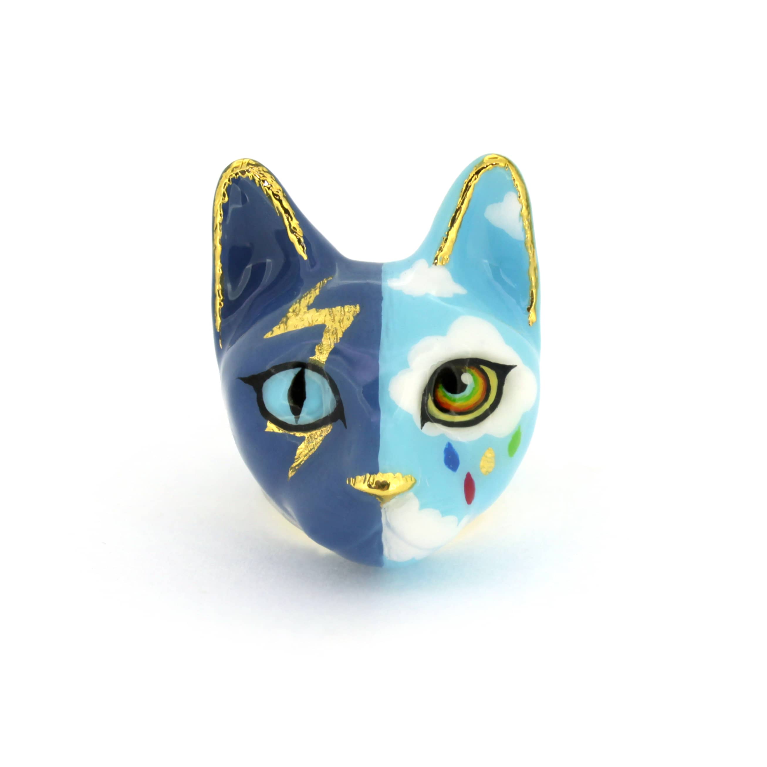 A handcrafted cat ring with an artistic split-face design—half stormy skies with lightning, half bright skies with clouds and a rainbow.