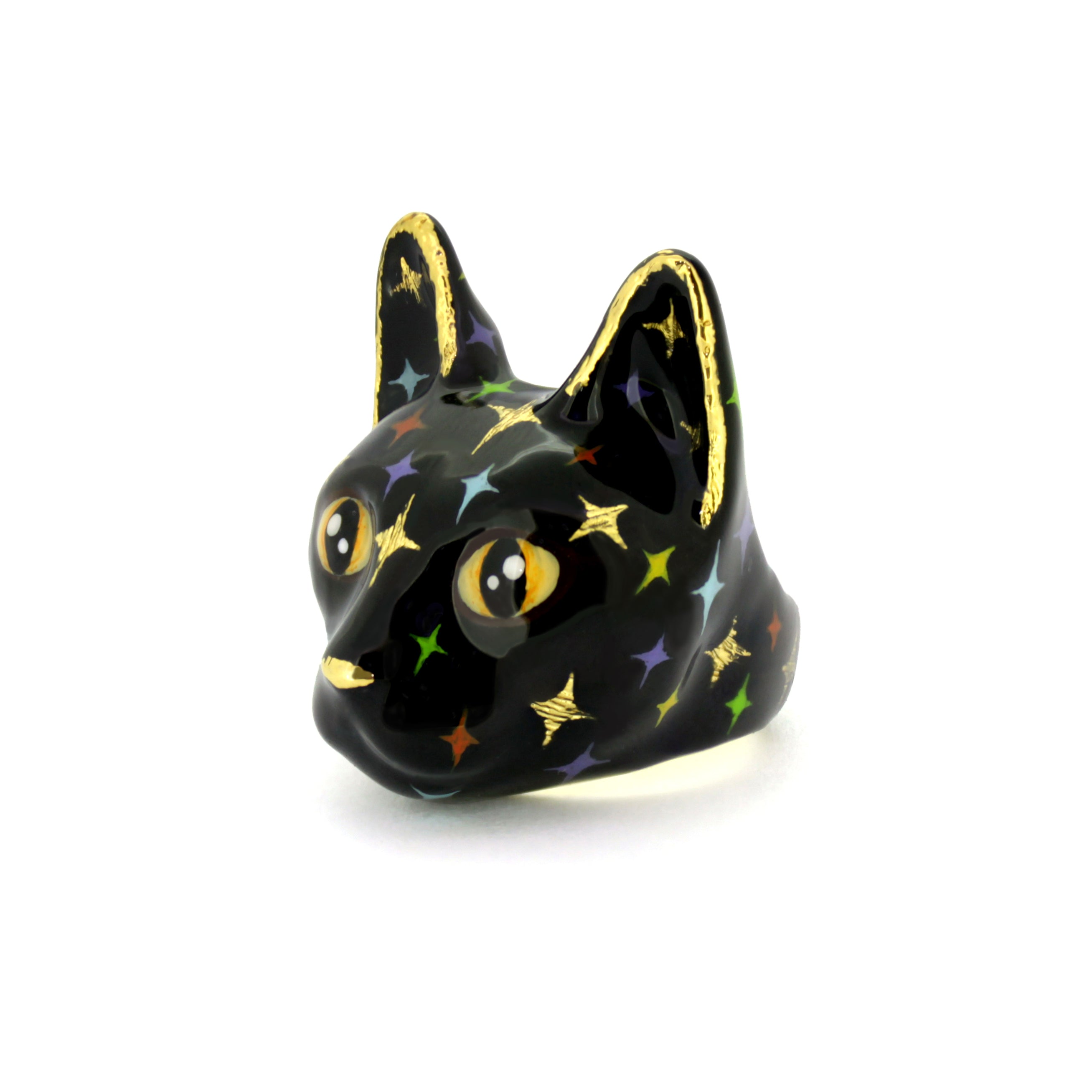 Whimsical black cat head ring with blue eyes and gold accents, featuring multicolored twinkle-shape details.