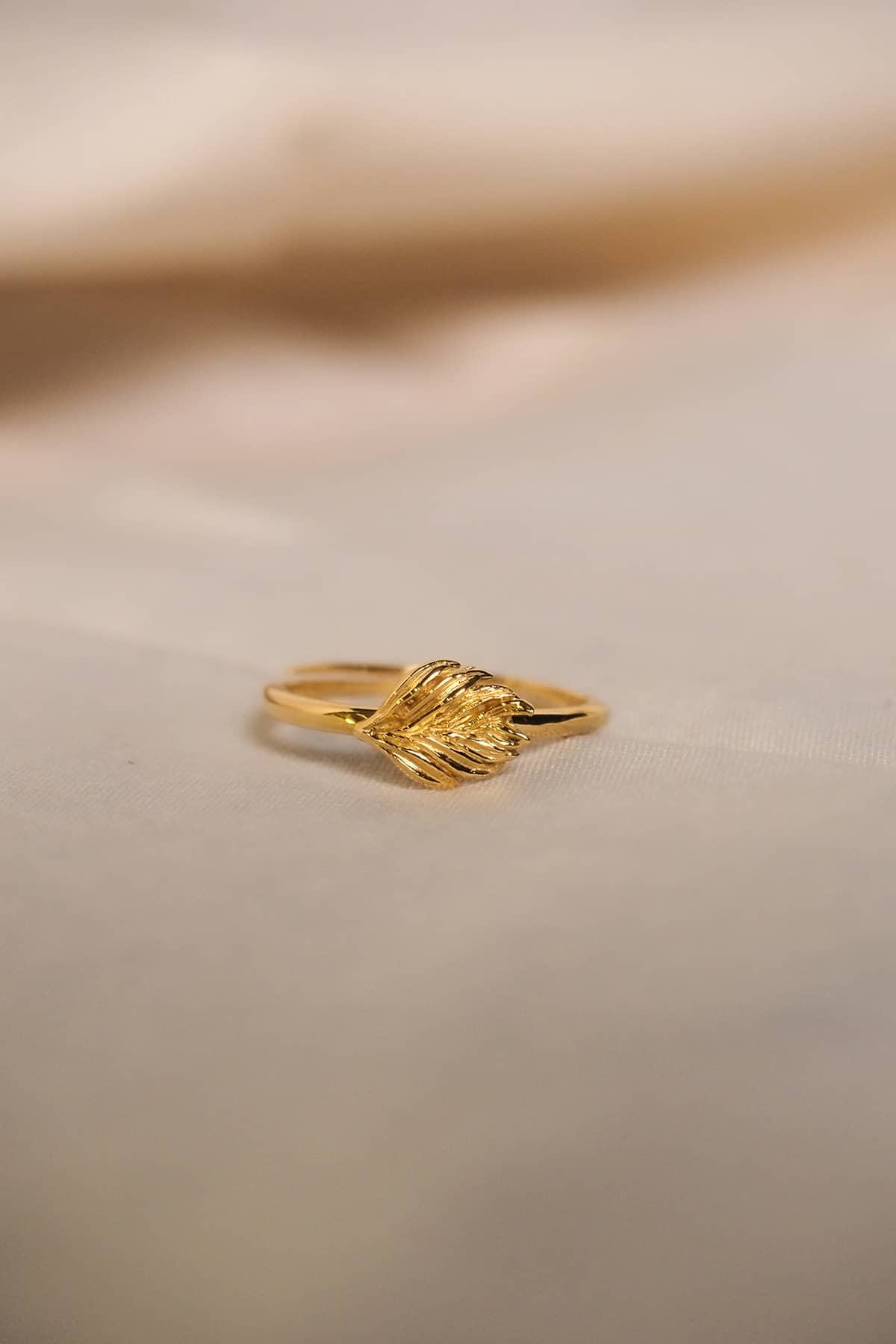 Close-up of a delicate gold ring featuring a unique leaf motif.