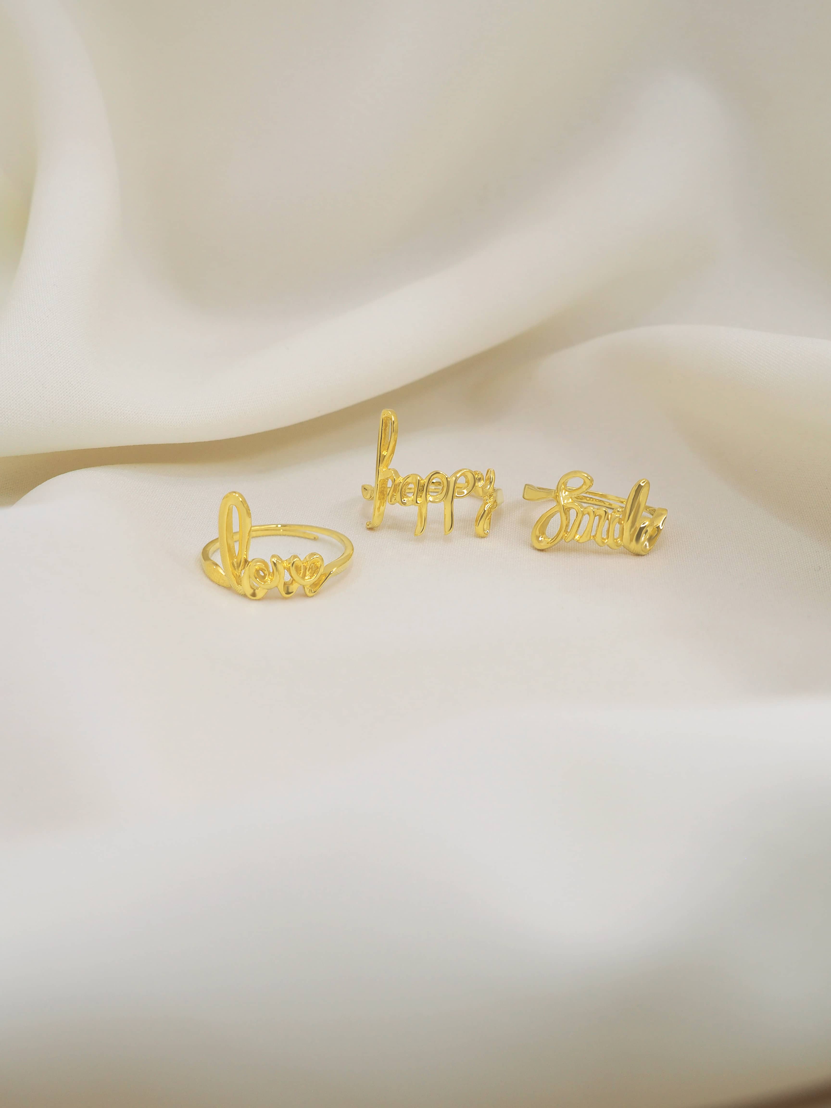 A beautiful golden ring with the words 'love', 'happy', and 'smile' elegantly crafted.