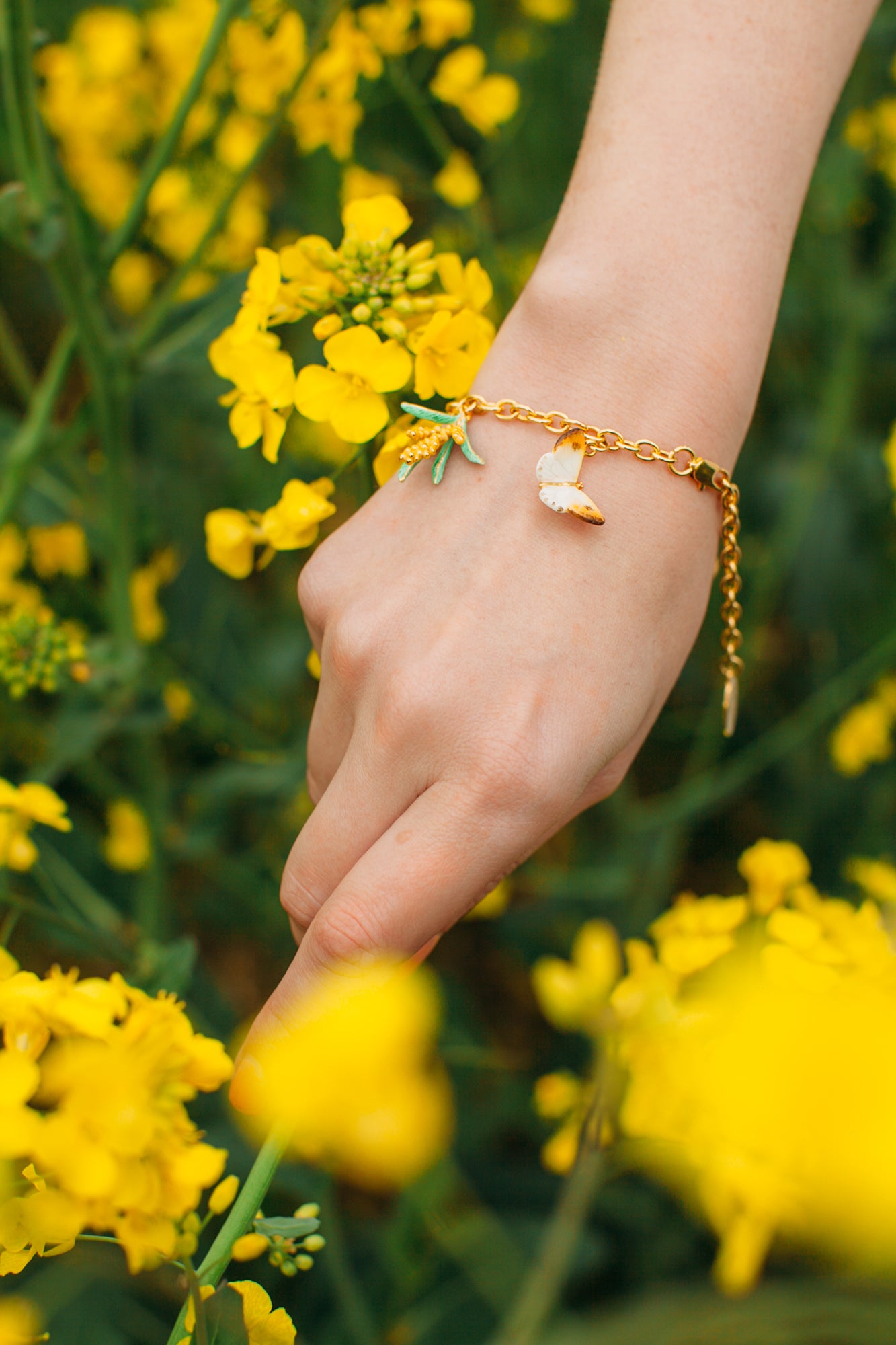 A whimsical gold charm bracelet featuring a fox and butterfly, perfect for nature lovers.