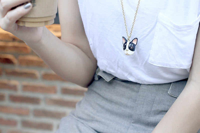 Casual outfit featuring a bulldog necklace and a coffee cup in hand.