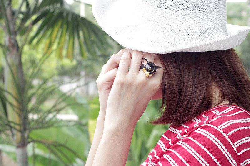 A playful dog ring worn by a woman in a casual outfit.