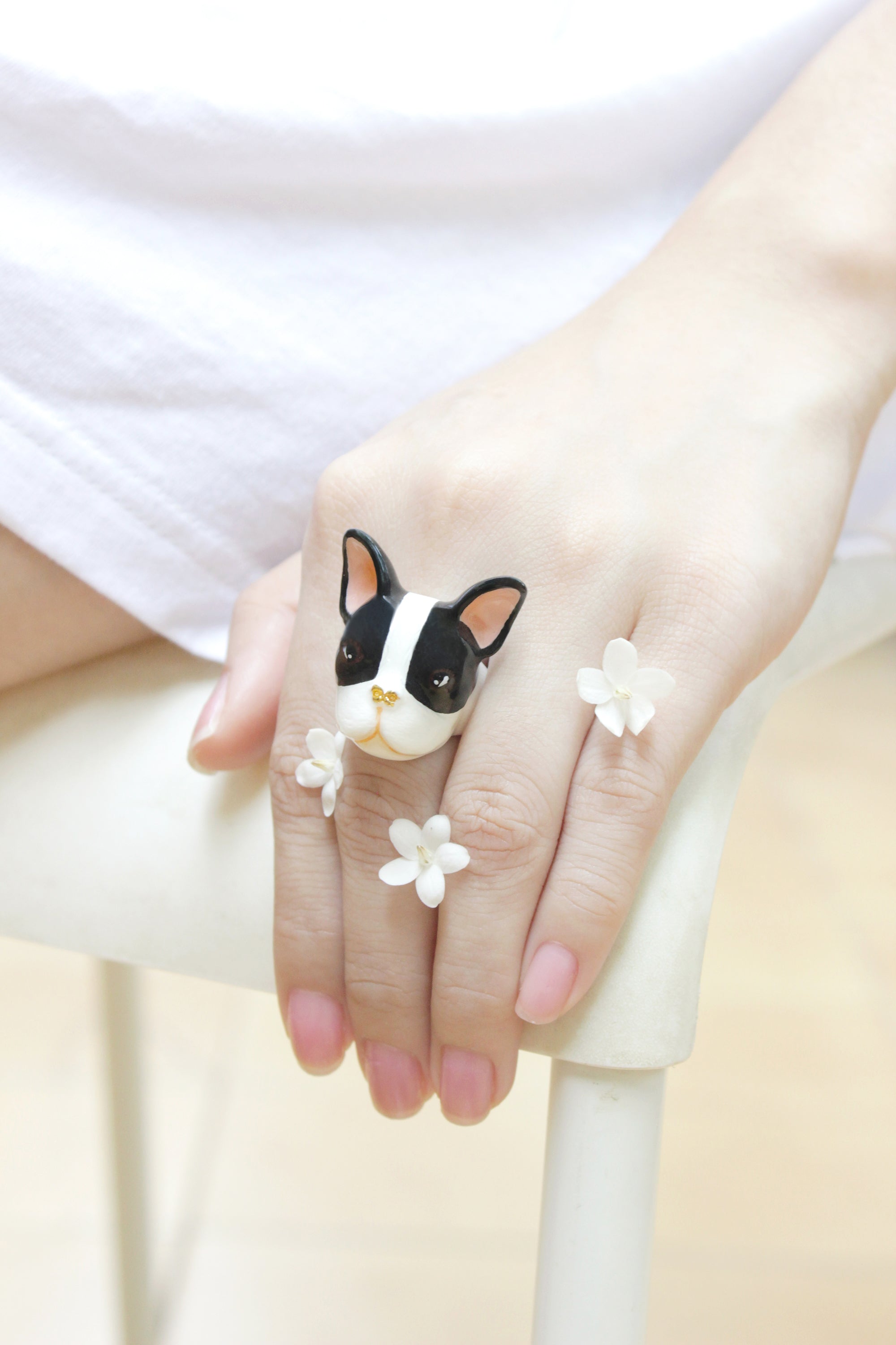 Handmade jewelry featuring a French Bulldog design on a finger.