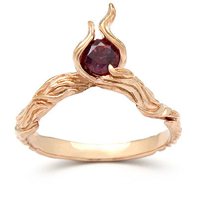 Artisan-crafted rose gold ring showcasing a flame design with a gemstone.