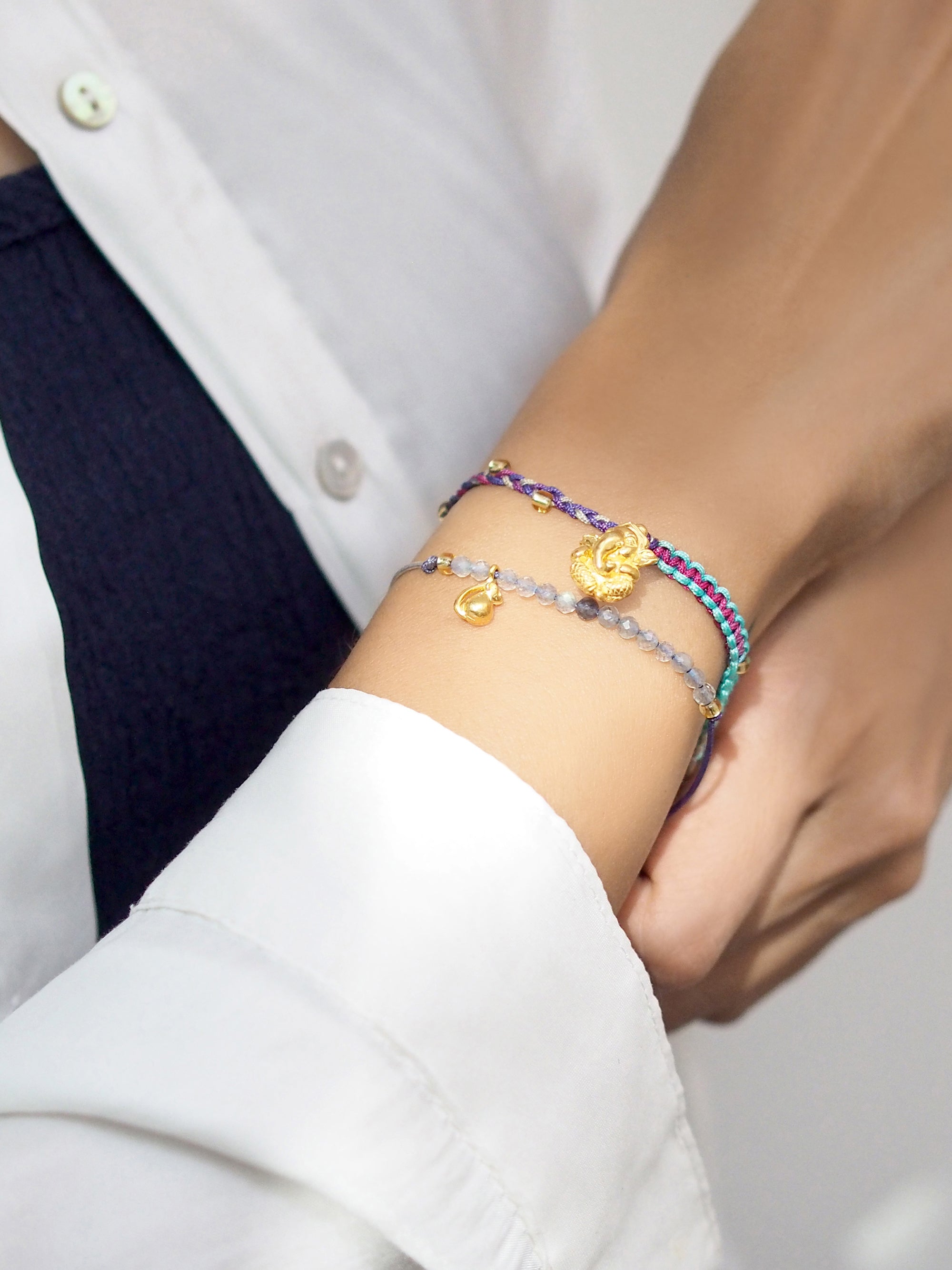 Stylish bracelets set with a Ganesh and Musika charm and beads on model's wrist