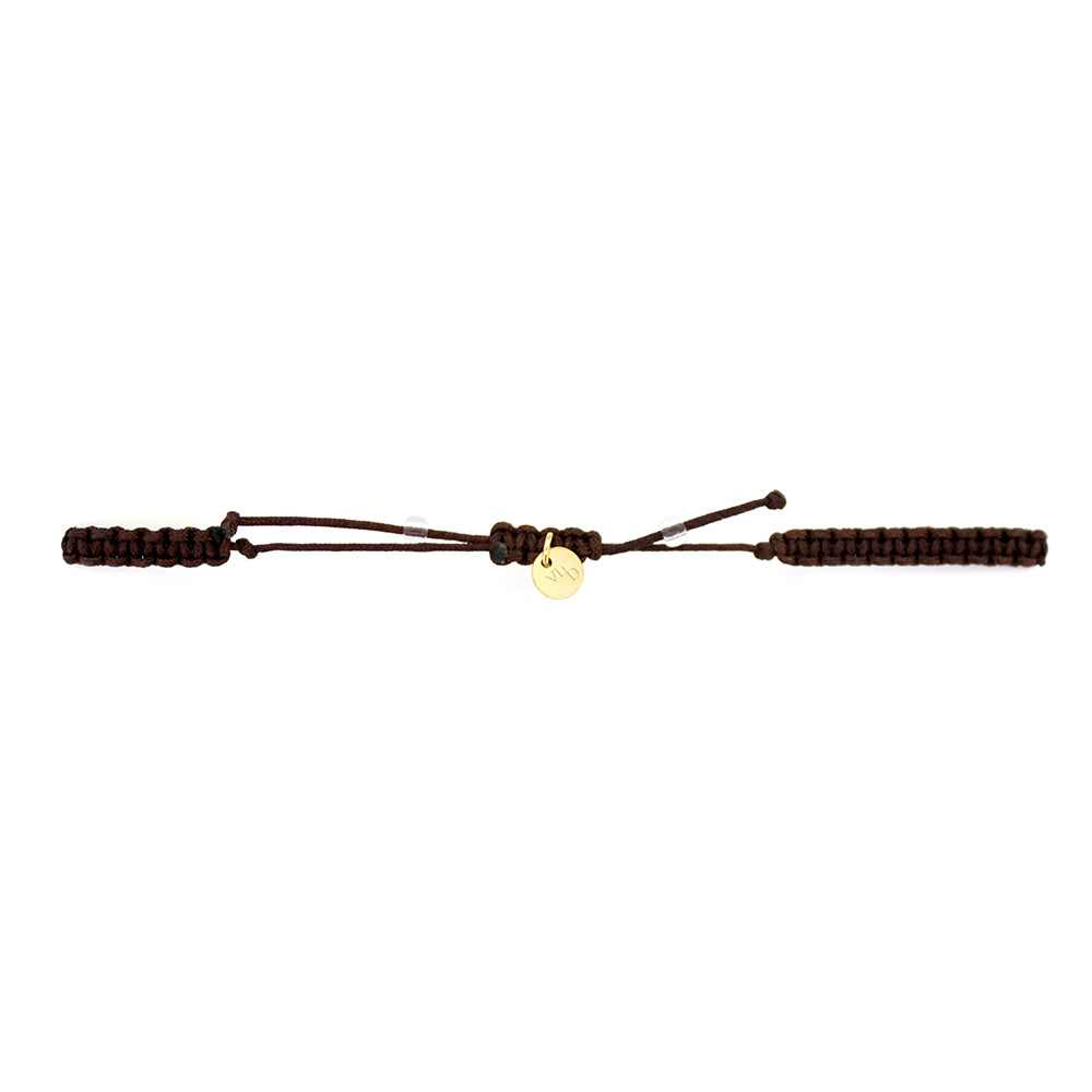A gold Tridevi Lakshmi charm and a gold owl charm on a brown bracelet with lemon jade stone.
