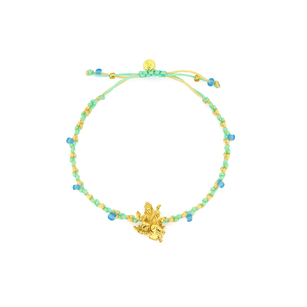 A bracelet in pastel green and yellow threads with colorful beads, featuring a gold Tridevi Sarasvati charm.