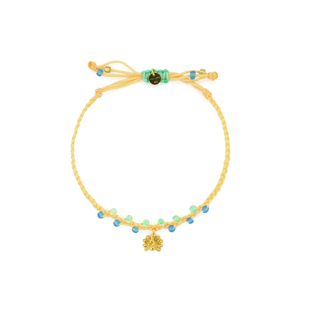 A bracelet in pastel green and yellow threads with colorful beads, featuring a gold peacock charm.