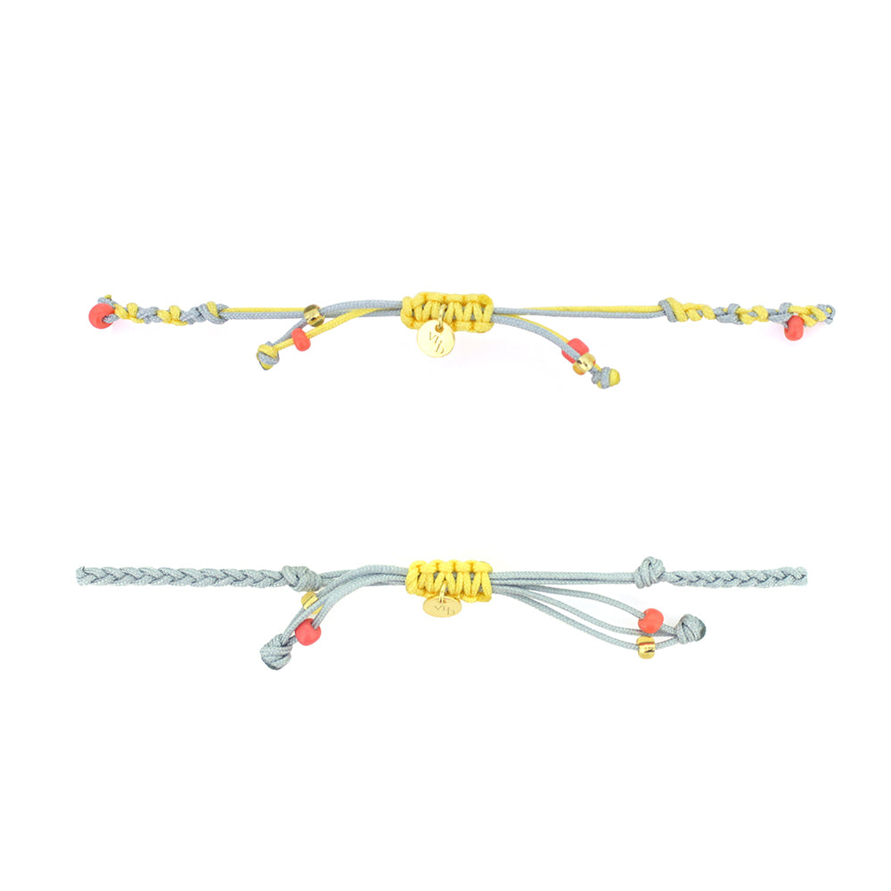 Two bracelets in light grey and yellow with pastel beads, featuring a gold Trimurti Brahma charm and a gold swan charm.