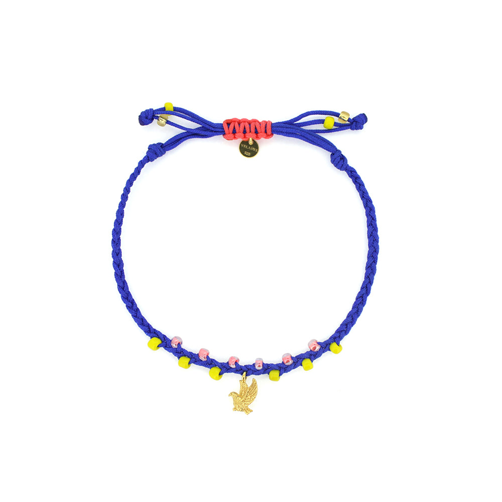 A bracelet in blue and red threads with colorful beads, featuring a gold garuda charm.