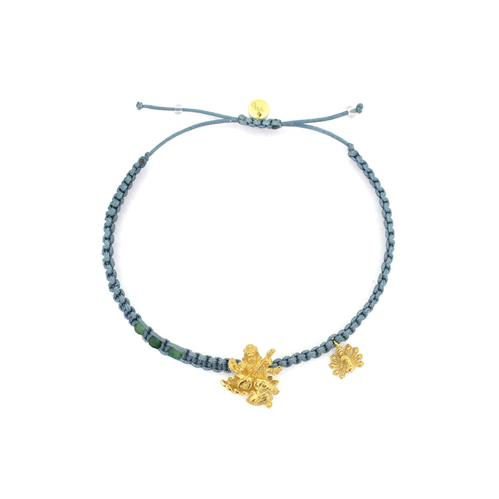 A gold Tridevi Sarasvati charm and a gold peacock charm on a green bracelet with aventurine stone.