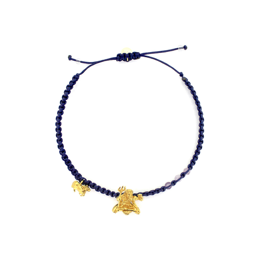 A gold Trimurti Shiva charm and a gold Nandi charm on a royal blue bracelet with amethyst-faced beads.