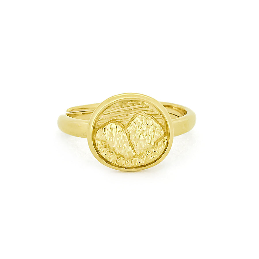Nature-inspired gold ring displays an intricately engraved landscape of mountain