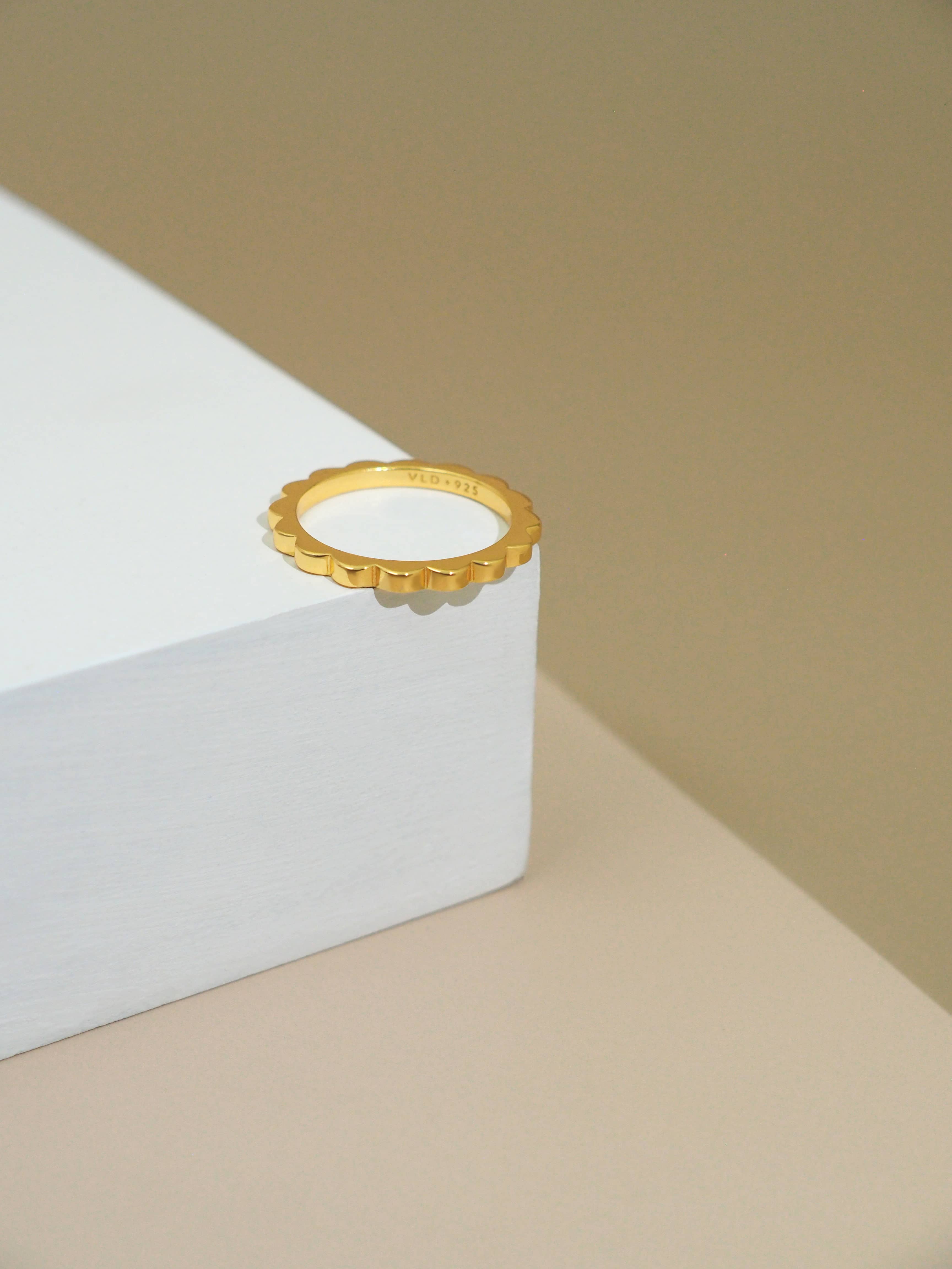 Cool, minimal, gold ring for everyday wear place on the white display.