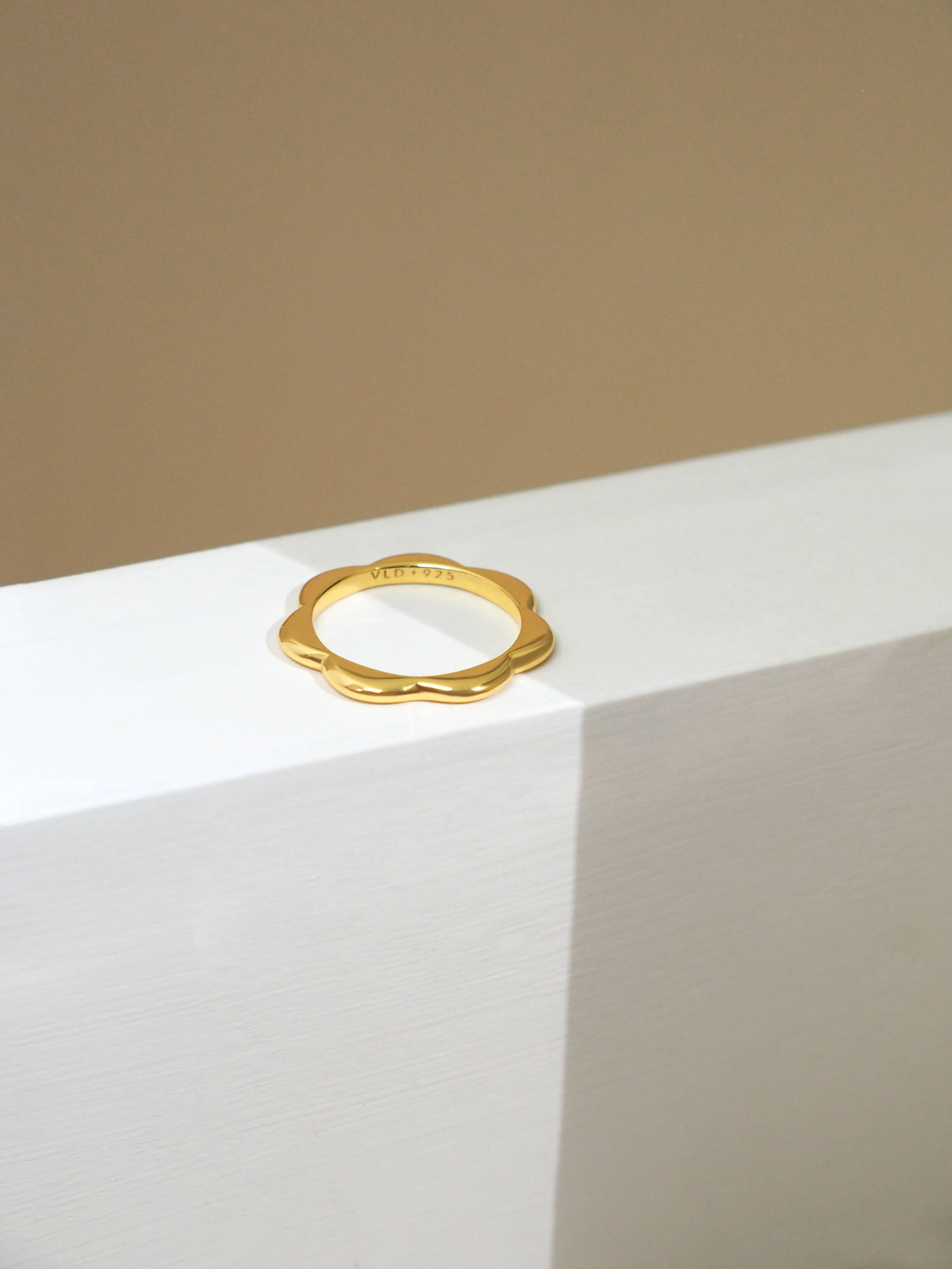 Minimal gold-plated stacking ring with a flower design for everyday wear.