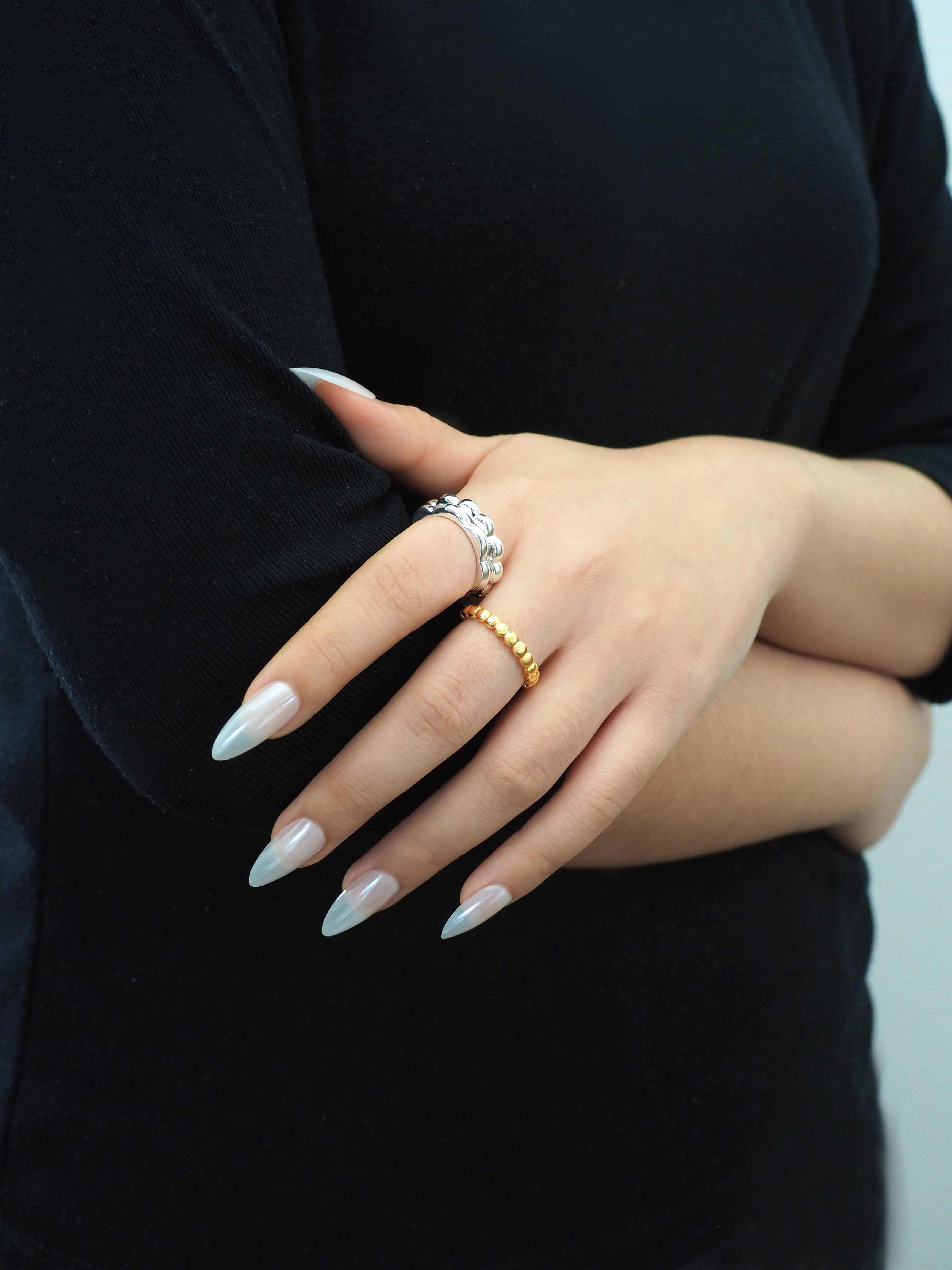 Model wearing modern design of gold and silver stacking rings 