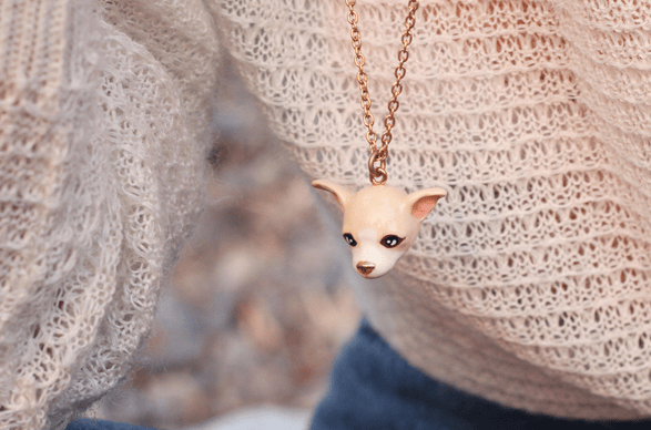 Adorable Chihuahua necklace on a person wearing a cozy sweater.
