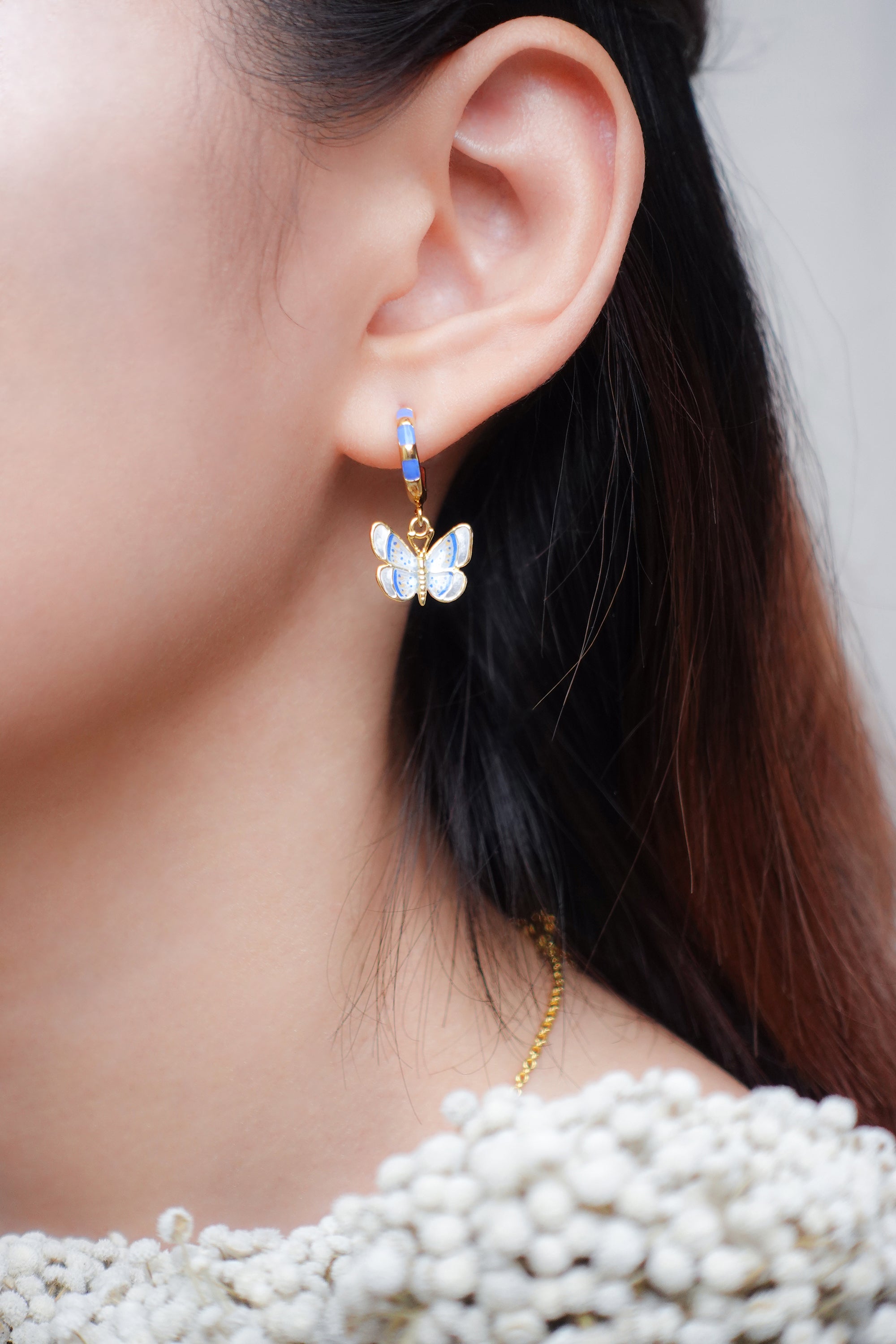 Close-up view of butterfly earrings showcasing intricate design and color.