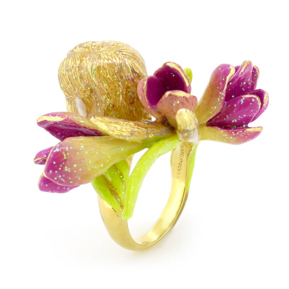 A whimsical ring featuring a nymph's face surrounded by pink and green flowers, perfect for fantasy jewelry lovers.