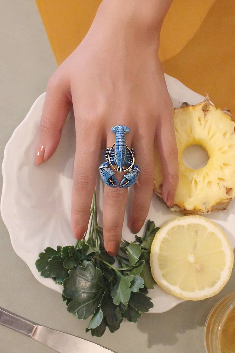 and showcasing a unique blue lobster ring with by pineapple and lemon.