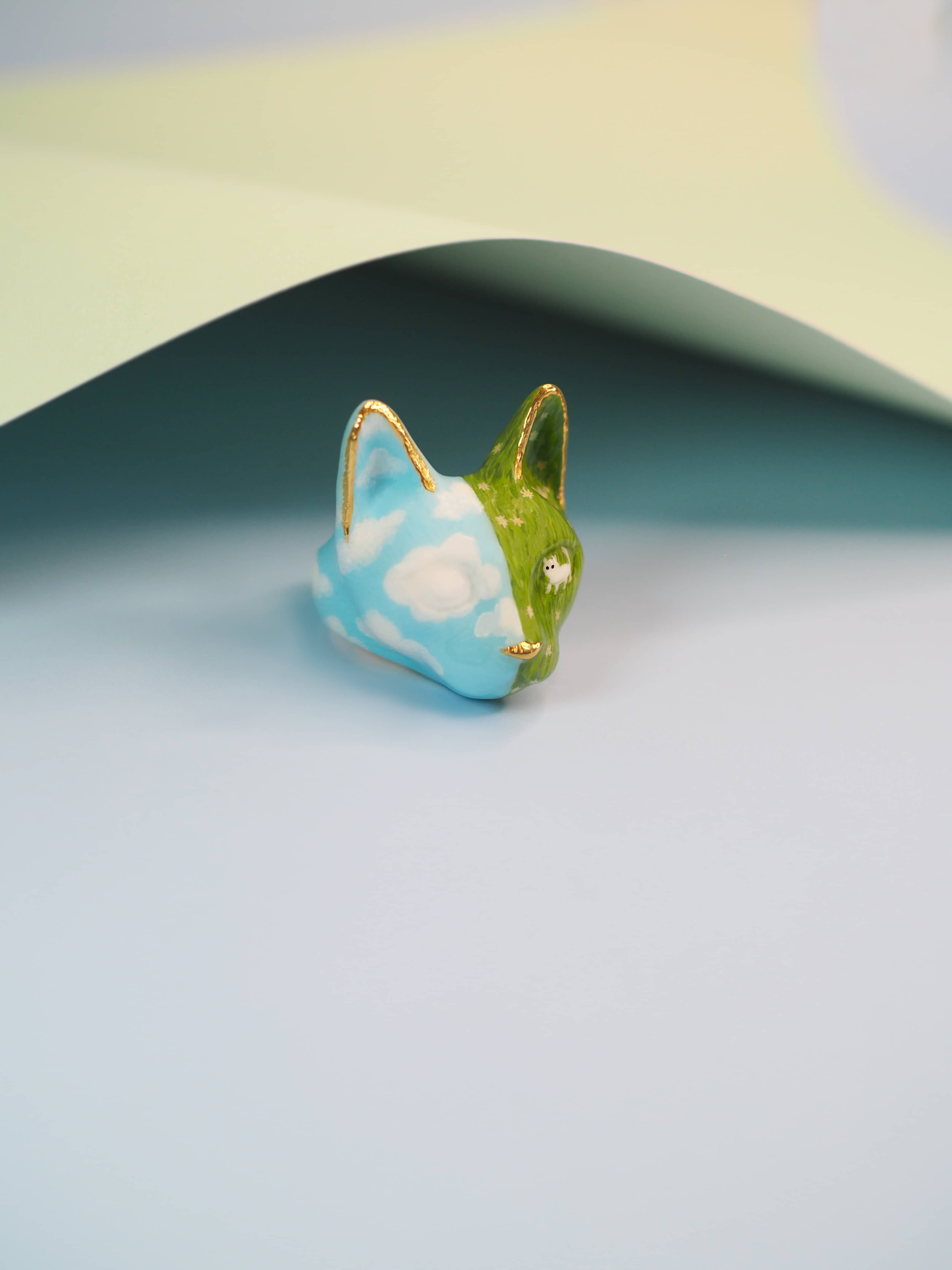 Colorful hand-painted cat ring showcasing a serene nature scene.