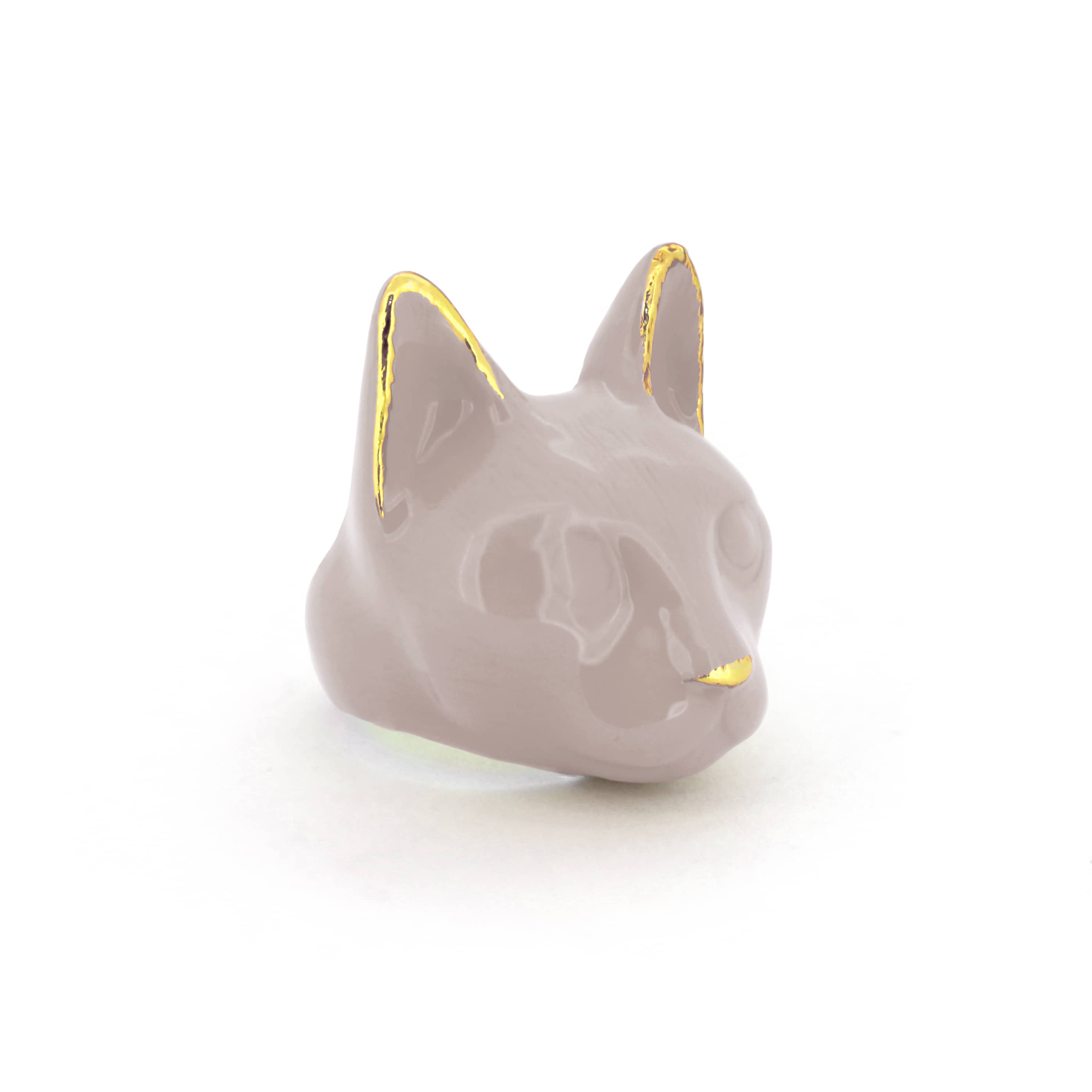 A dusty pink cat's head ring with gold accents on the ears and a small gold nose