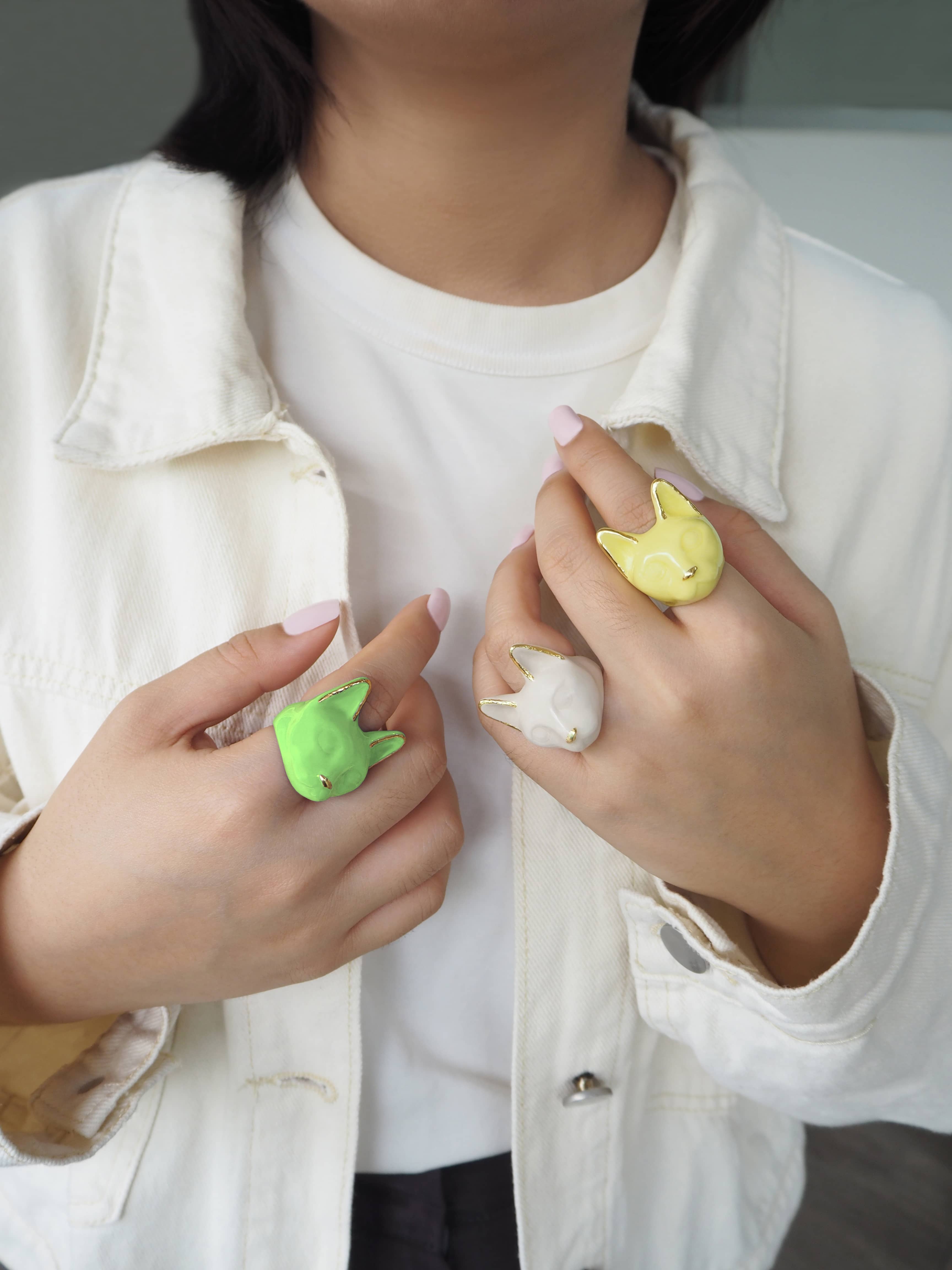 Three colorful cat rings worn on fingers, cat ring collection for summer.