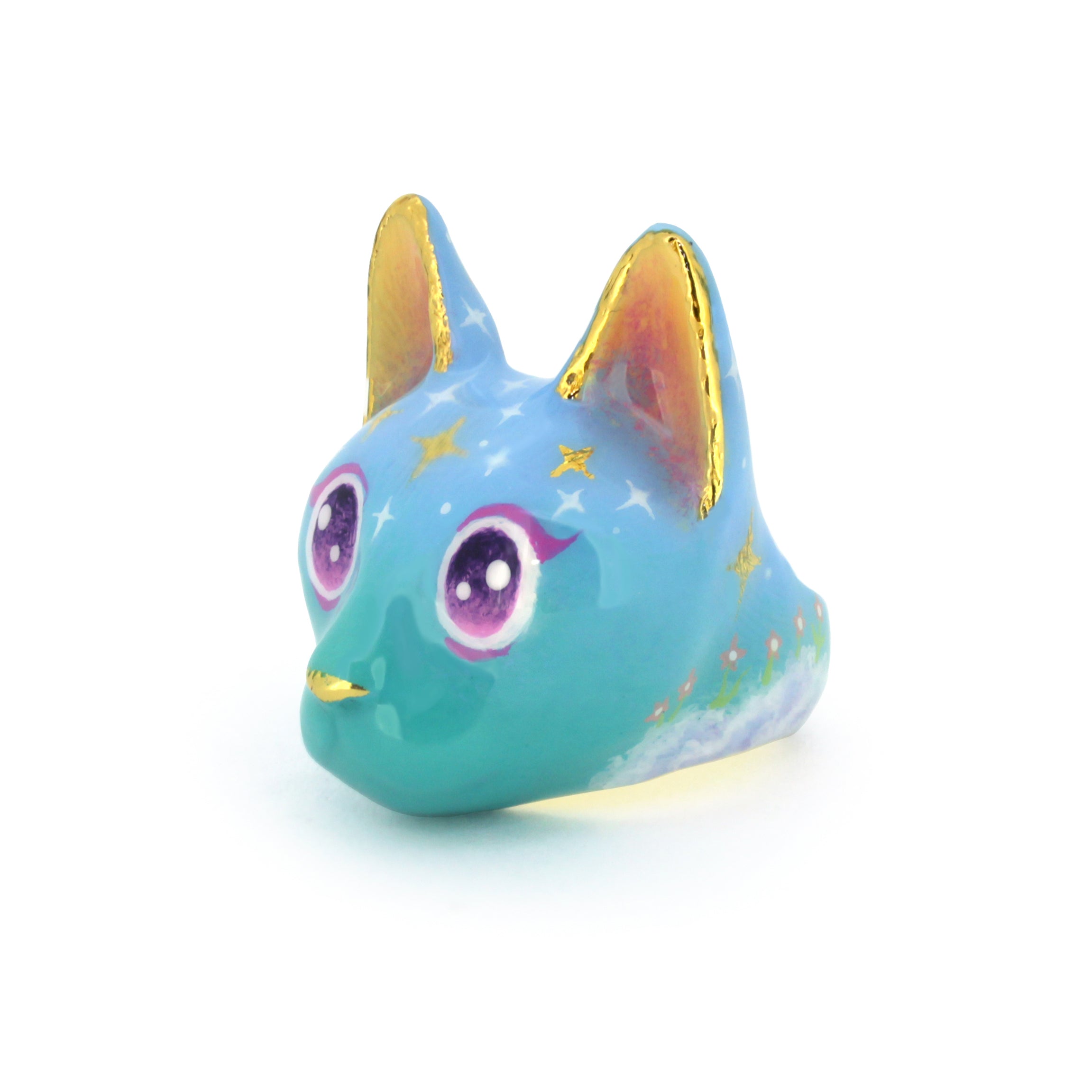 Adorable cat ring in a soft blue color featuring yellow ears and large, sparkling purple eyes and star-like patterns on its forehead
