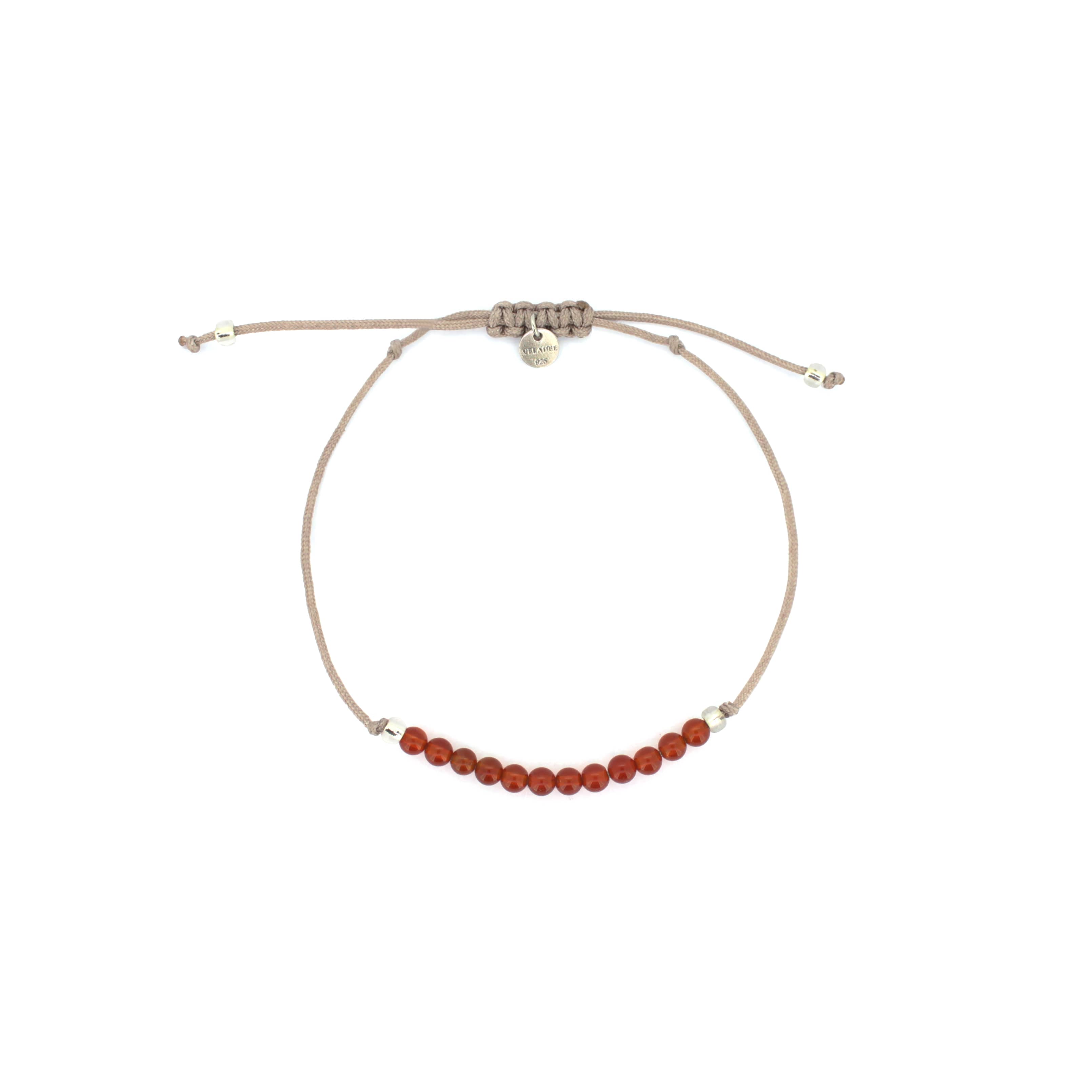 A beige bracelet with  red agate-round beads