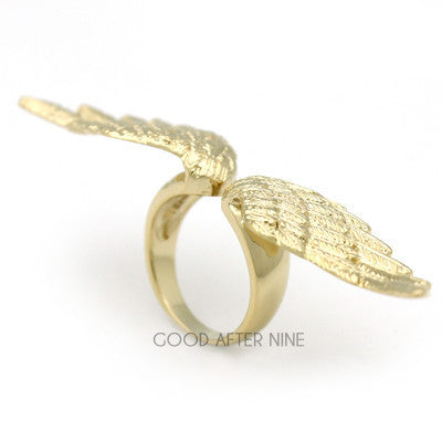 A stylish golden ring featuring intricate wing designs.