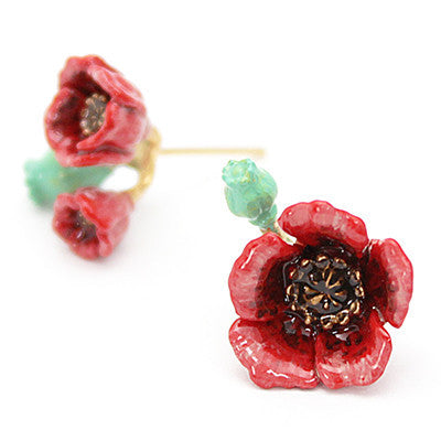 Handcrafted red floral earrings with green accents and brown centers.

