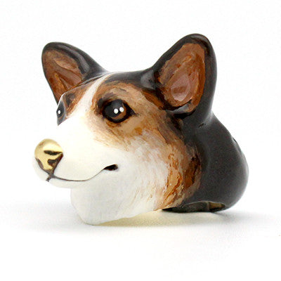 A cute, hand-painted ring featuring corgi head with large black eyes, and soft, dark brown and white fur details.