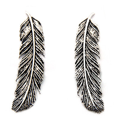 Bold silver earrings designed as delicate feathers for a trendy look.