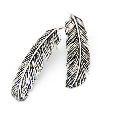 Bold silver earrings designed as delicate feathers for a trendy look.