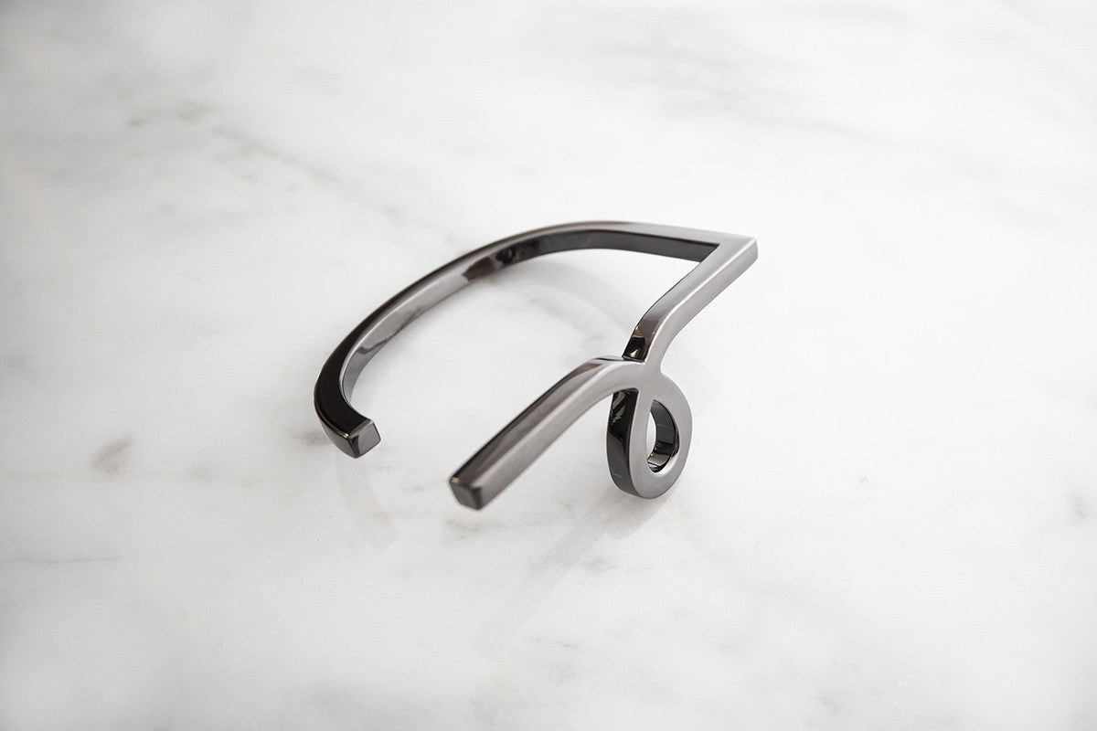 Minimal style bangle with a stylized script small 'L' design