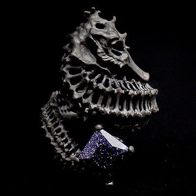 Unique ring designed with a reef-inspired seahorse skeleton and a shimmering purple gemstone.
